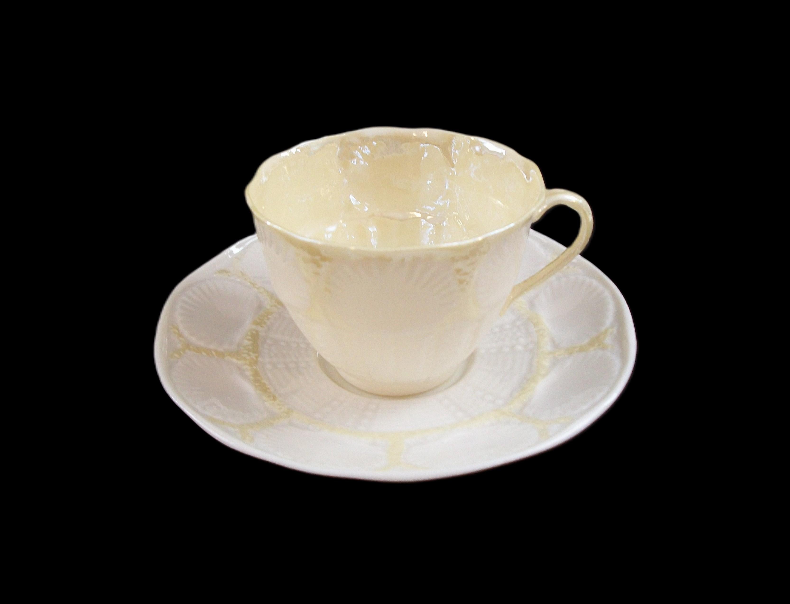BELLEEK (Fabricante) - ' New Shell - Amarillo ' (Patrón) - Taza y platillo de té de porcelana de época - con esmalte iridiscente amarillo en el interior de la taza y reflejos en la taza y el platillo - tercera marca de fabricante verde en la parte