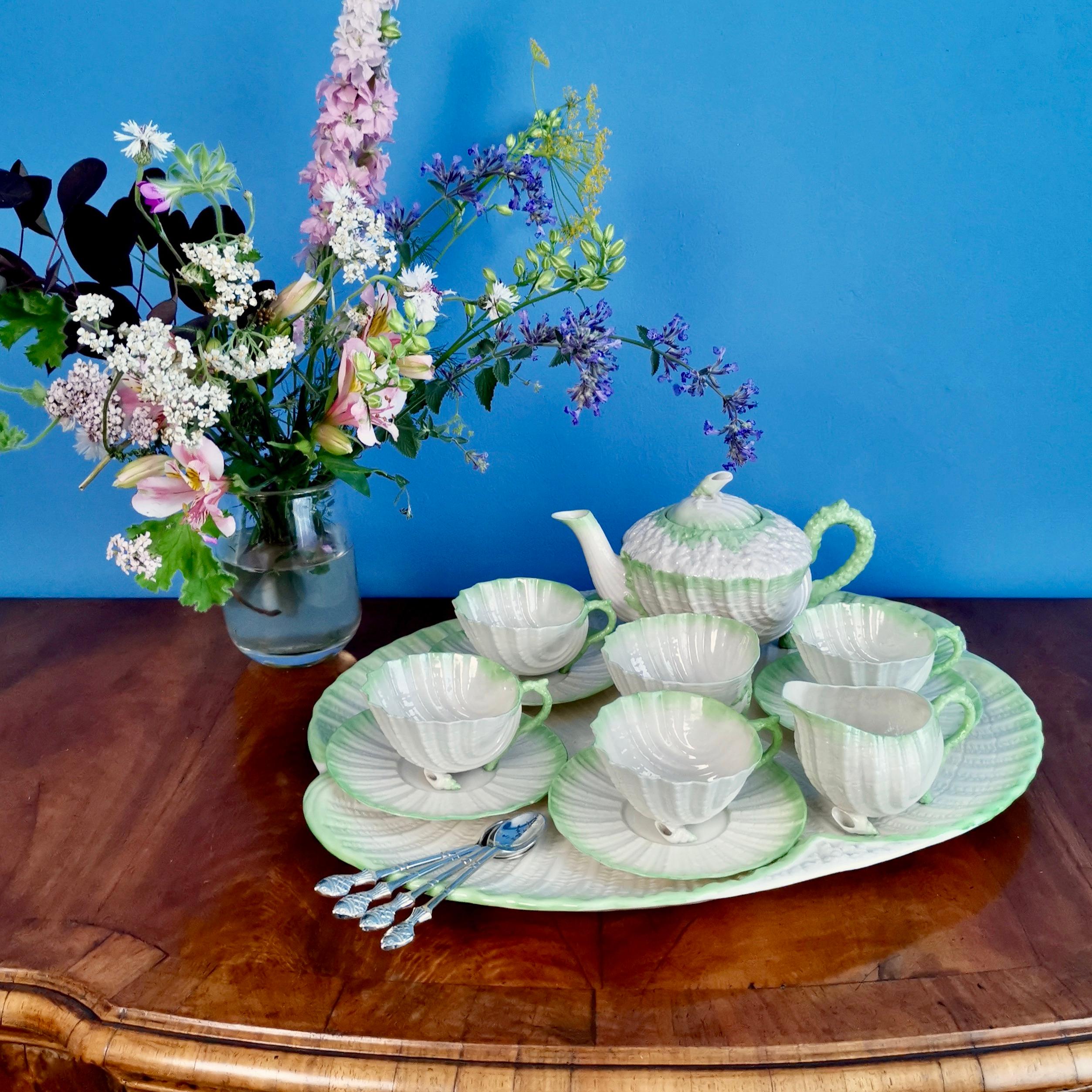 This is a rare and gorgeous Belleek cabaret tea service for four in the green Neptune design made by Belleek some time between 1891 and 1926, most probably in the 1890s. The service consists of a teapot, four teacups and saucers, a milk jug and a
