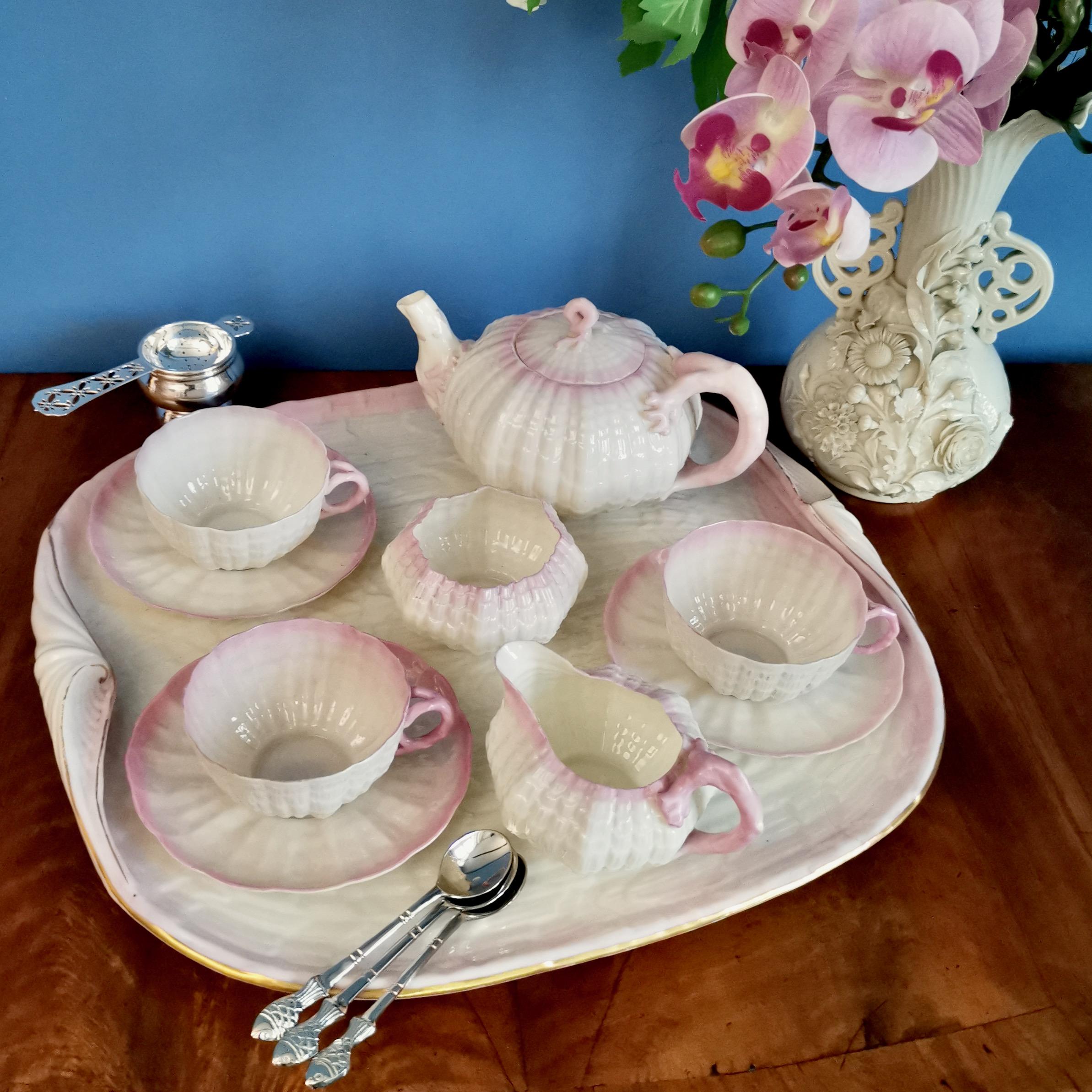 This is a beautiful Belleek cabaret set in the pink Tridacna design, consisting of a teapot, three teacups and saucers, a milk jug and a sugar bowl, all placed on a large tray. All items carry the 2nd Black Mark, which was used between 1891 and
