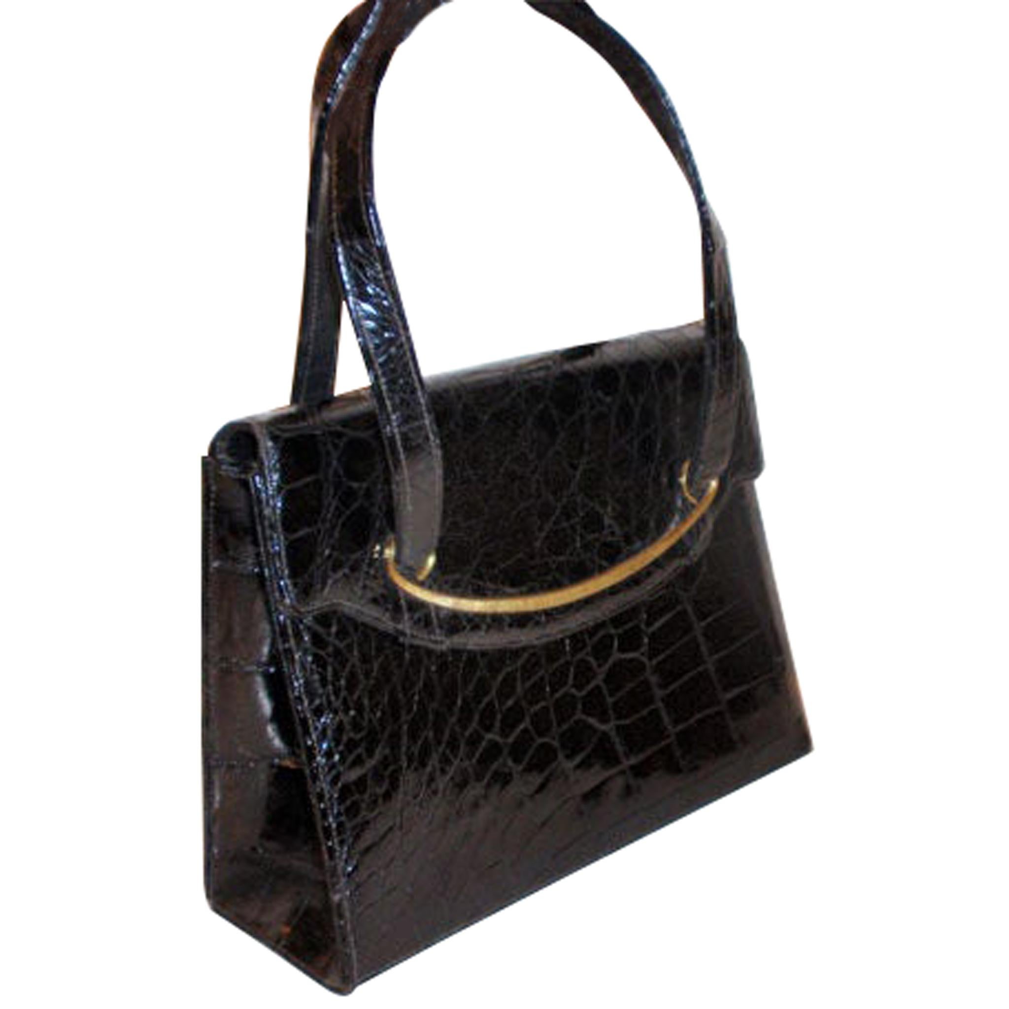 This is a black crocodile handbag by Bellesto, from 1960. It has two handles which are 6