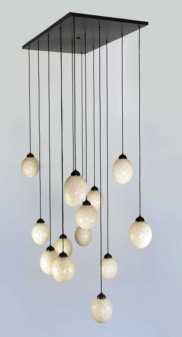 14 pierced ostrich eggs suspended from a bronze finish canopy. Braided silk wires.
Fixture uses candelabra base bulbs.
25 watt max. for ostrich eggs
Height can be adjusted on site.