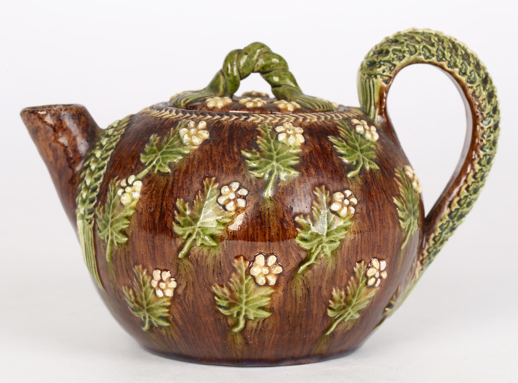 A rare antique art pottery teapot and cover decorated with floral designs from the Bellevue pottery in Rye, Sussex and dating from the 19th century. Typical of Rye pottery the earthenware teapot is in typical Rye style and color applied with flowers