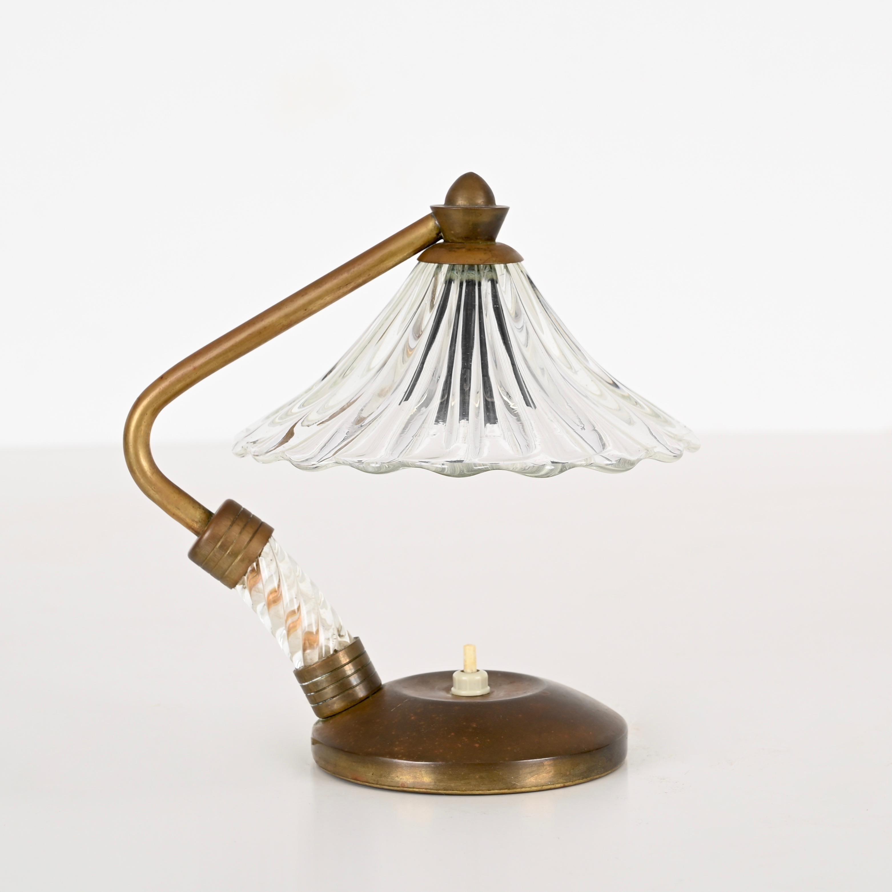 Magnifique lampe de table en verre de Murano et laiton. Cette lampe incroyablement élégante a été conçue par Eleg Barovier et fabriquée en Italie au début des années 40.  

L'abat-jour de cette lampe finement travaillée rappelle la forme d'une fleur