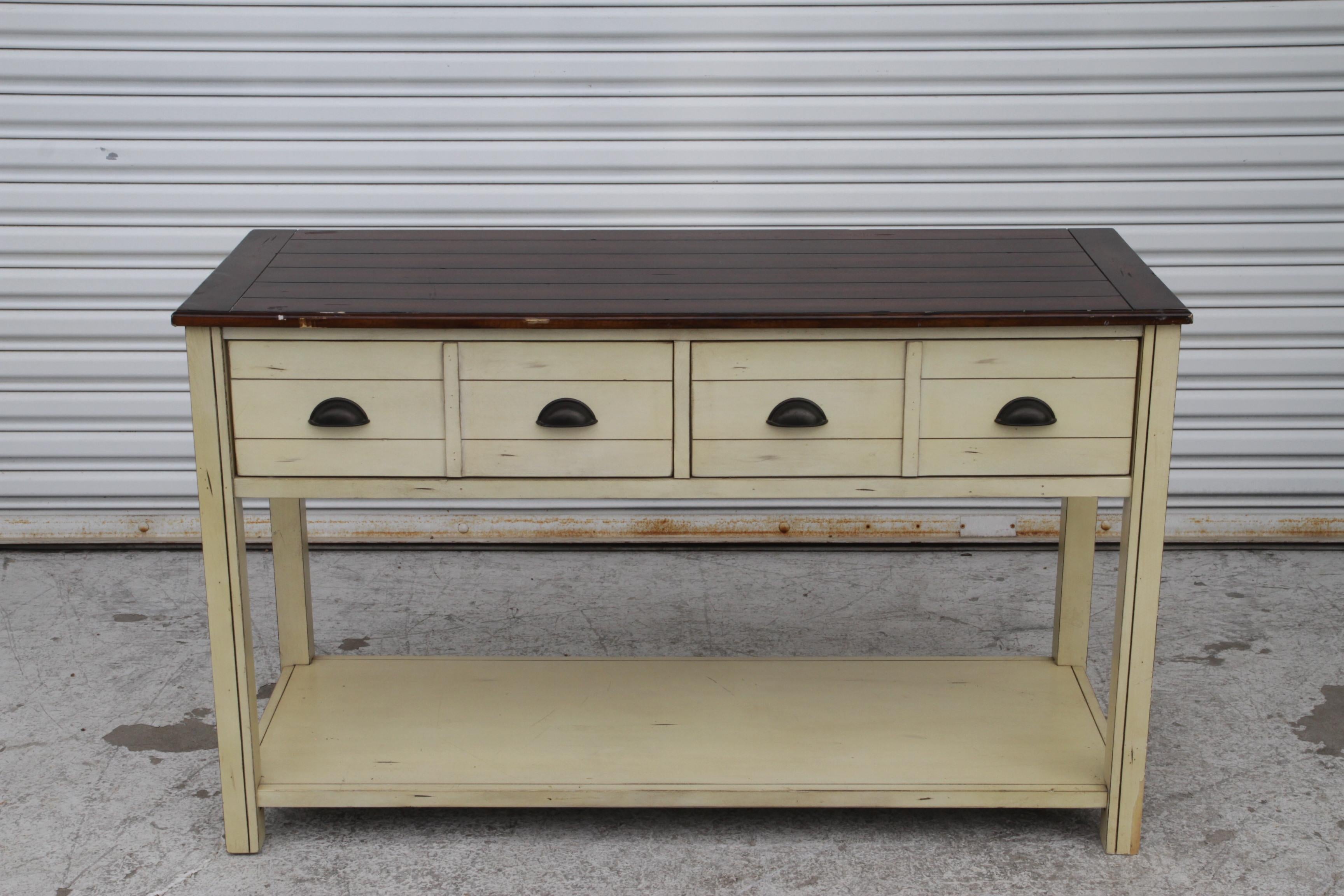 Añade un elemento de estilo a tu salón, estudio o recibidor con esta mesa de sofá de dos cajones. Esta mesa cuenta con una serie de cuatro cajones para organizar manoplas, llaves y otros objetos esenciales en la entrada o mantener mandos a