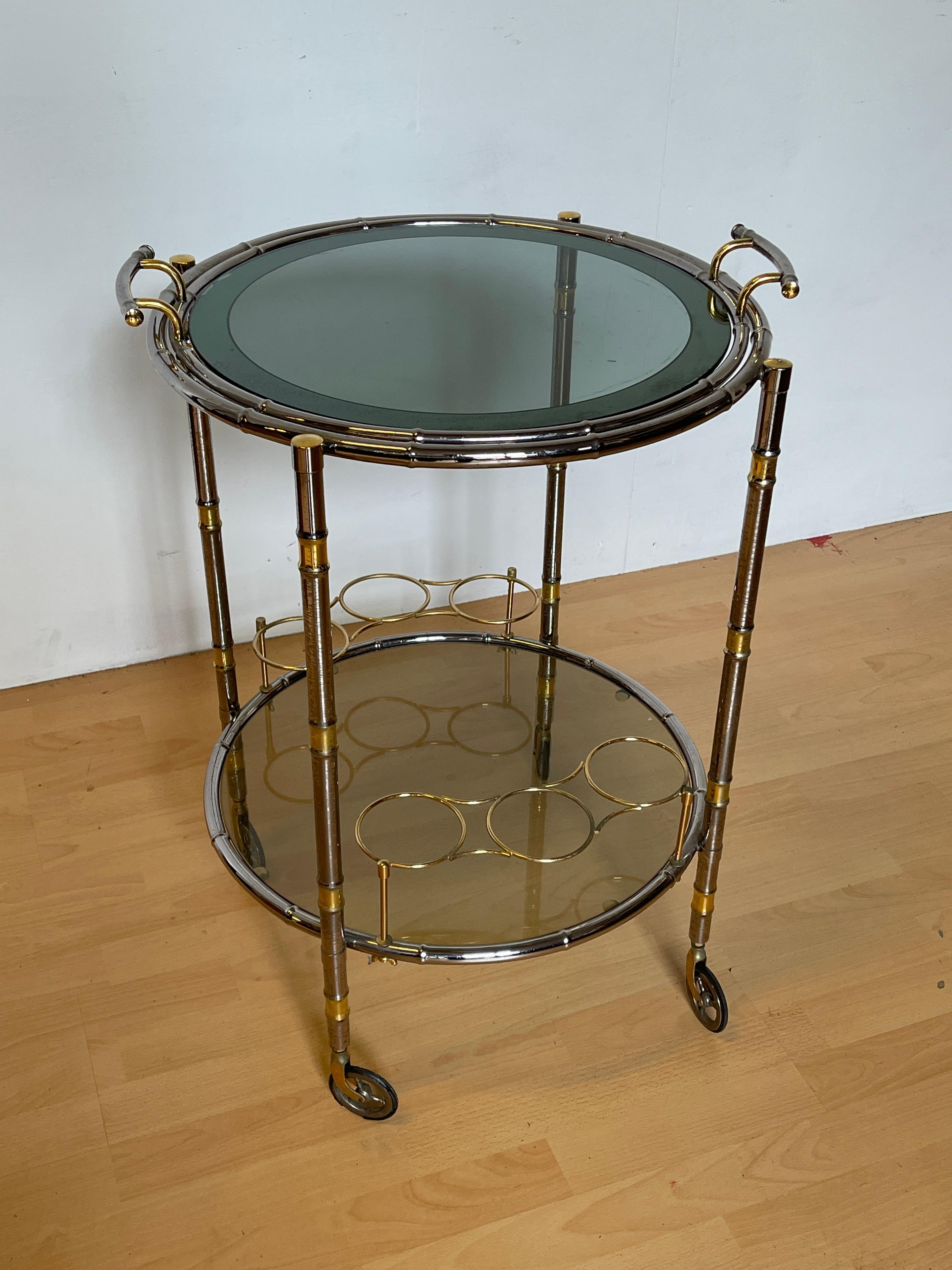 Magnifique chariot de bar en métal argenté et verre avec détails dorés, 20e siècle

Un élégant chariot de bar italien au design sophistiqué et moderne, réalisé en métal avec une finition chromée et dorée. Cette table basse est dotée de deux plateaux