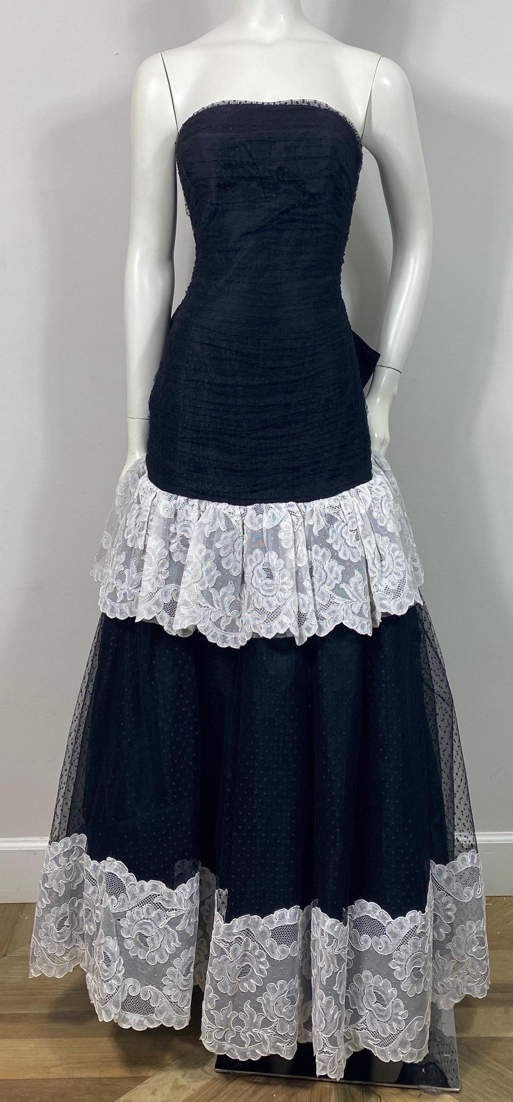Bellville Sassoon Late 1980’s Black and White Point D’Esprit Gown - Size 8  This late 80’s early 90’s vintage gown is made of a black point d’esprit that is trimmed in white lace. The top of the strapless gown has a ruched bodice that is fitted