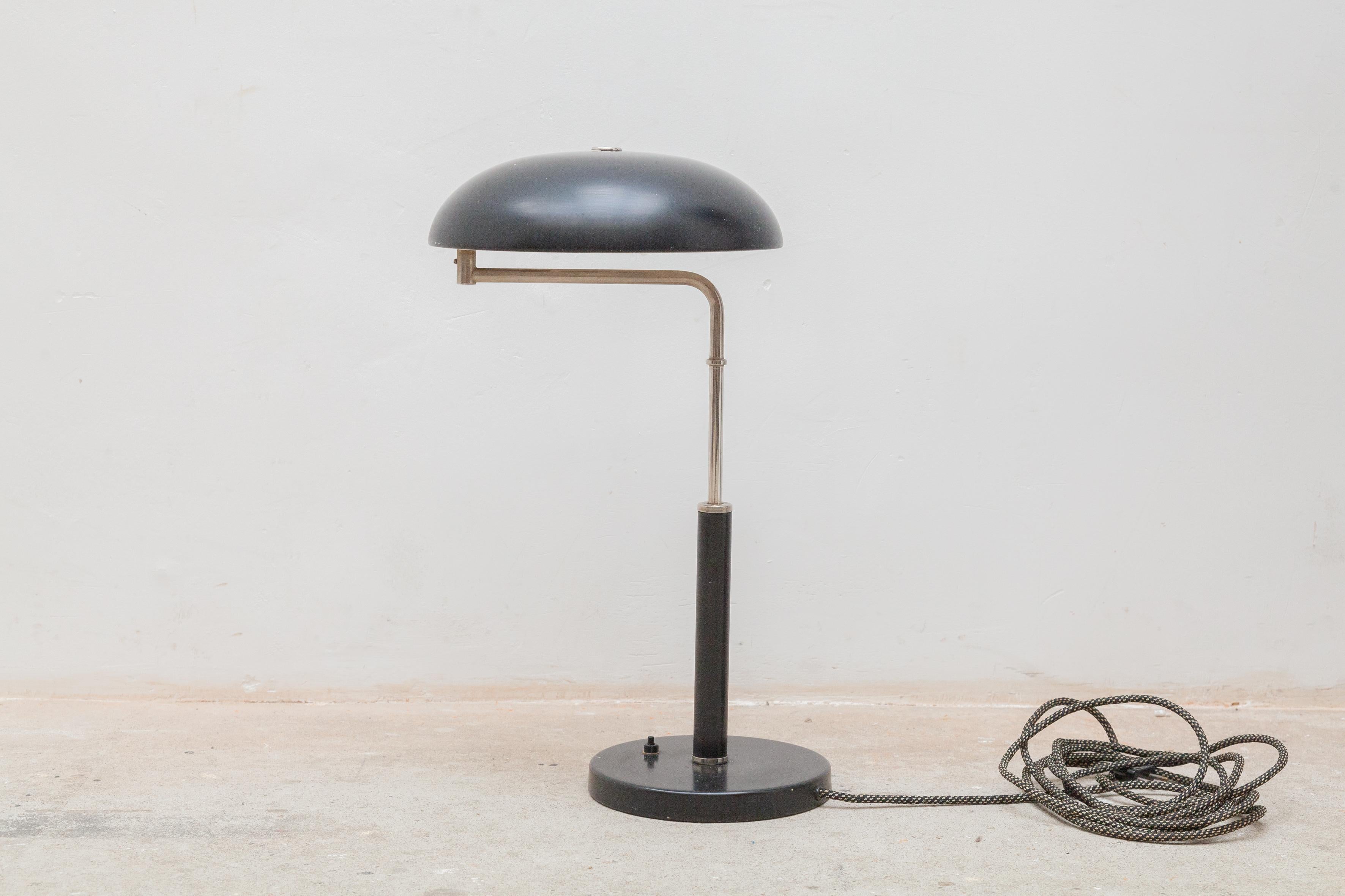 Stylish Bauhaus design-classic desk/table adjustable lamp. This design classic table lamp has a beautifully shaped, blackened shade with matching, circular base. Multiple adjustability options: the arm swivels, as does the shade, and the arm height