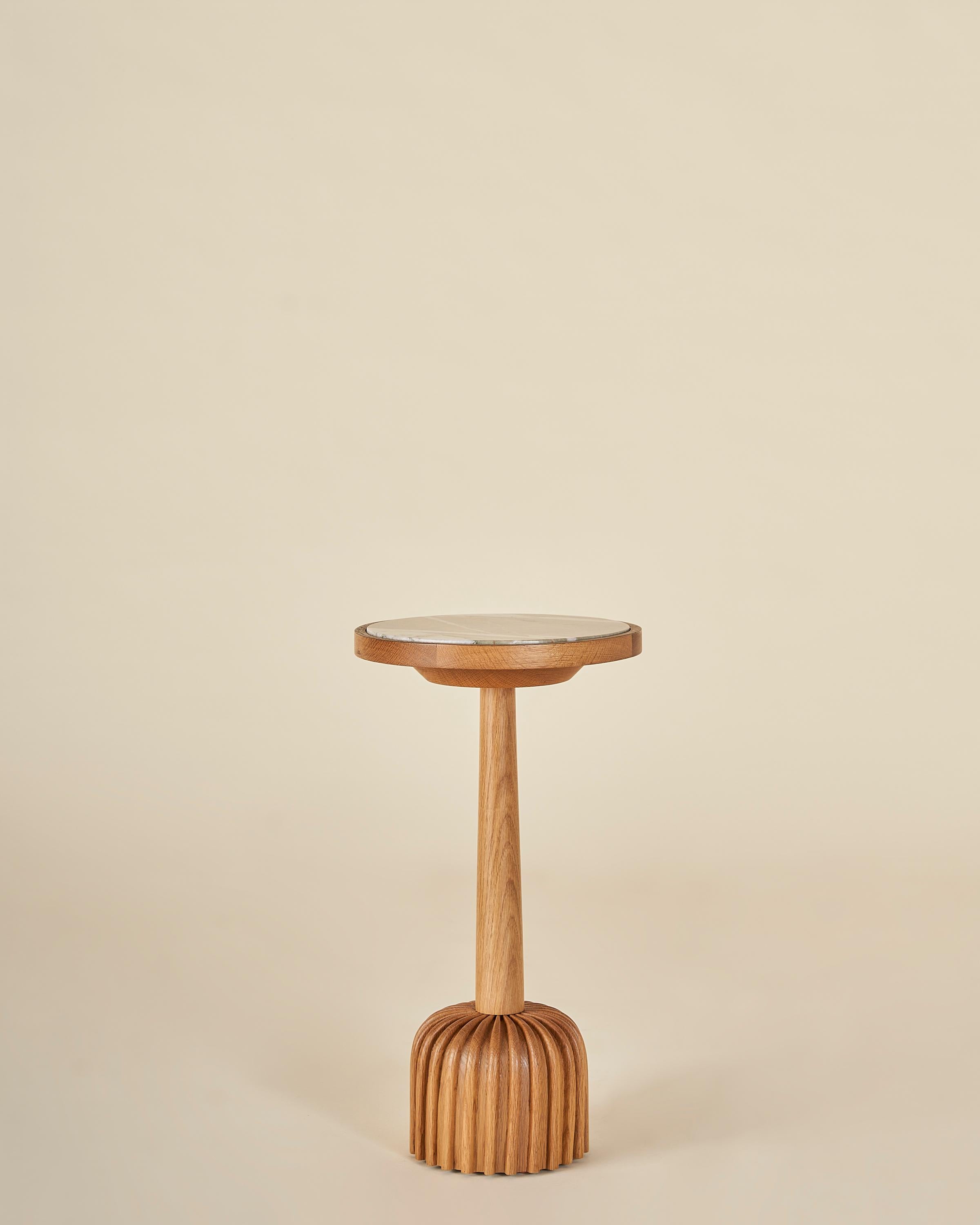 Form meets function with this classic cocktail table or side table. The piece features a specialized reeded solid oak base and an inset Fairy Verderra green marble top. The petite size allows for ease of movement around any room, though the marble