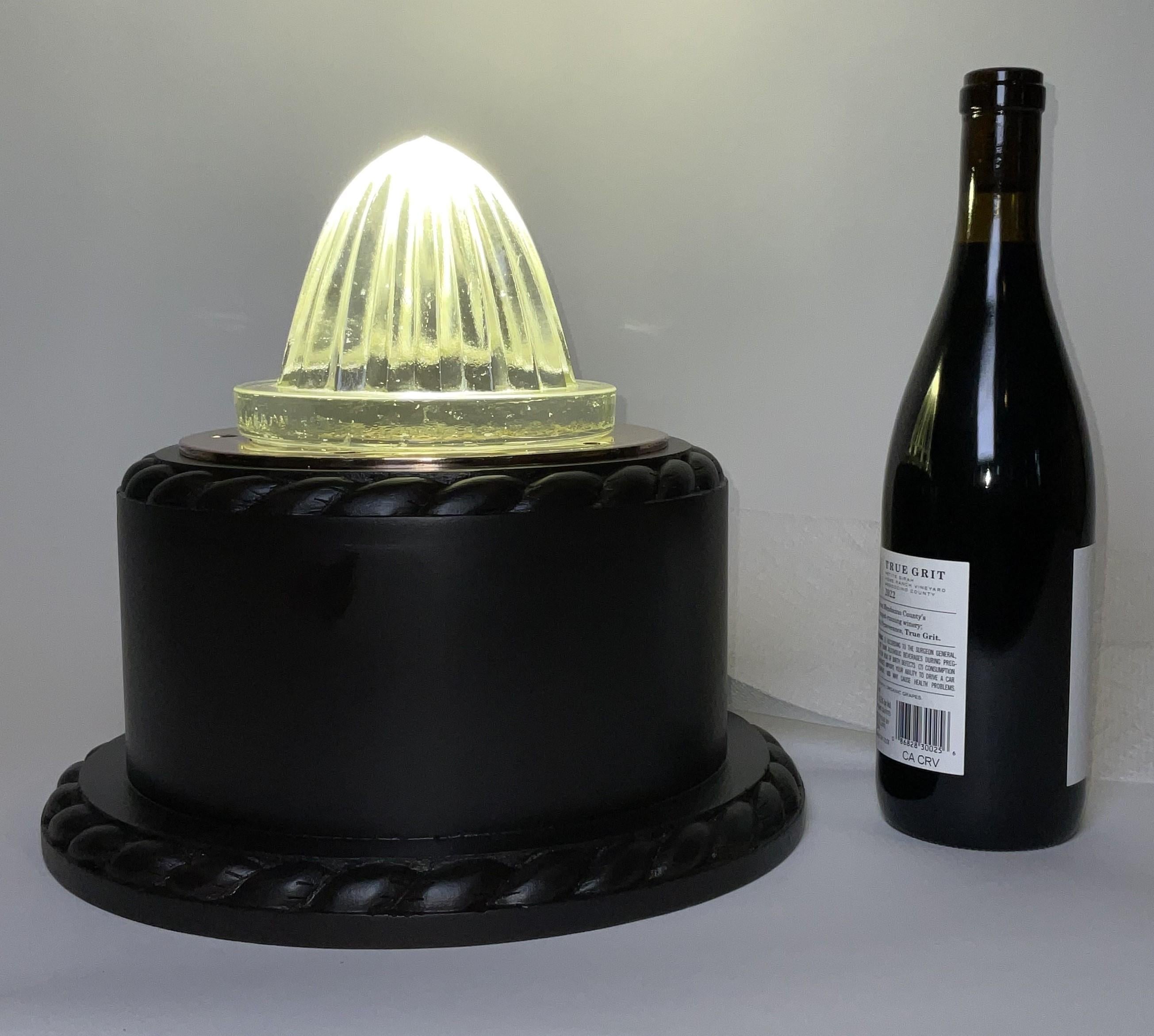 Glass deck prism that has been repurposed as an accent light. The prism has been inverted and lit from below. Fitted to a mahogany base with rope carved borders and wired with an LED bulb.

Weight:    10 lbs.
Overall Dimensions:    11