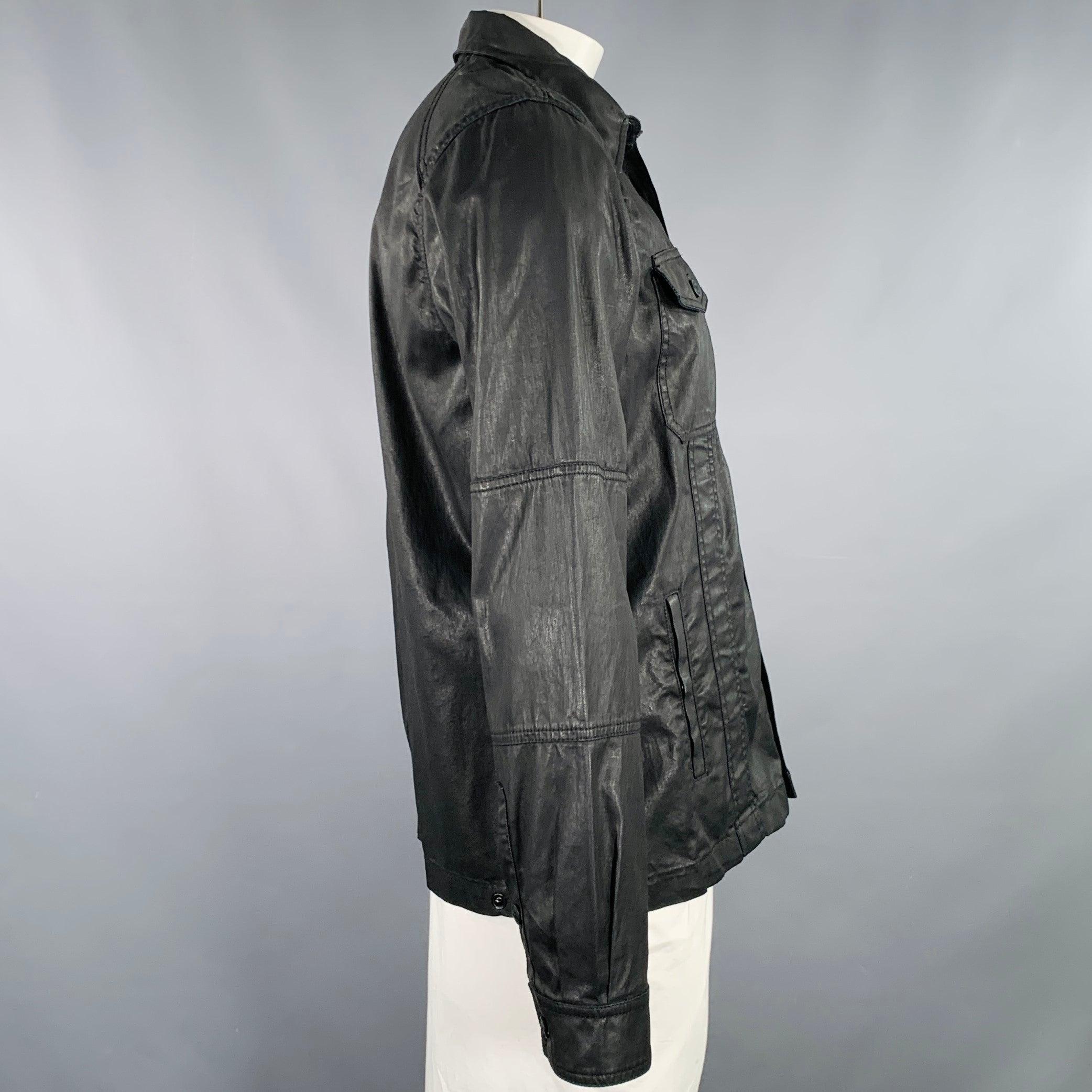 BELSTAFF jacket
in a black coated cotton woven fabric featuring a trucker style, two buttoned chest pockets, and button closure. Made in Romania.New with Tags. 

Marked:   XL 

Measurements: 
 
Shoulder: 16.5 inches Chest: 44 inches Sleeve: 26.5