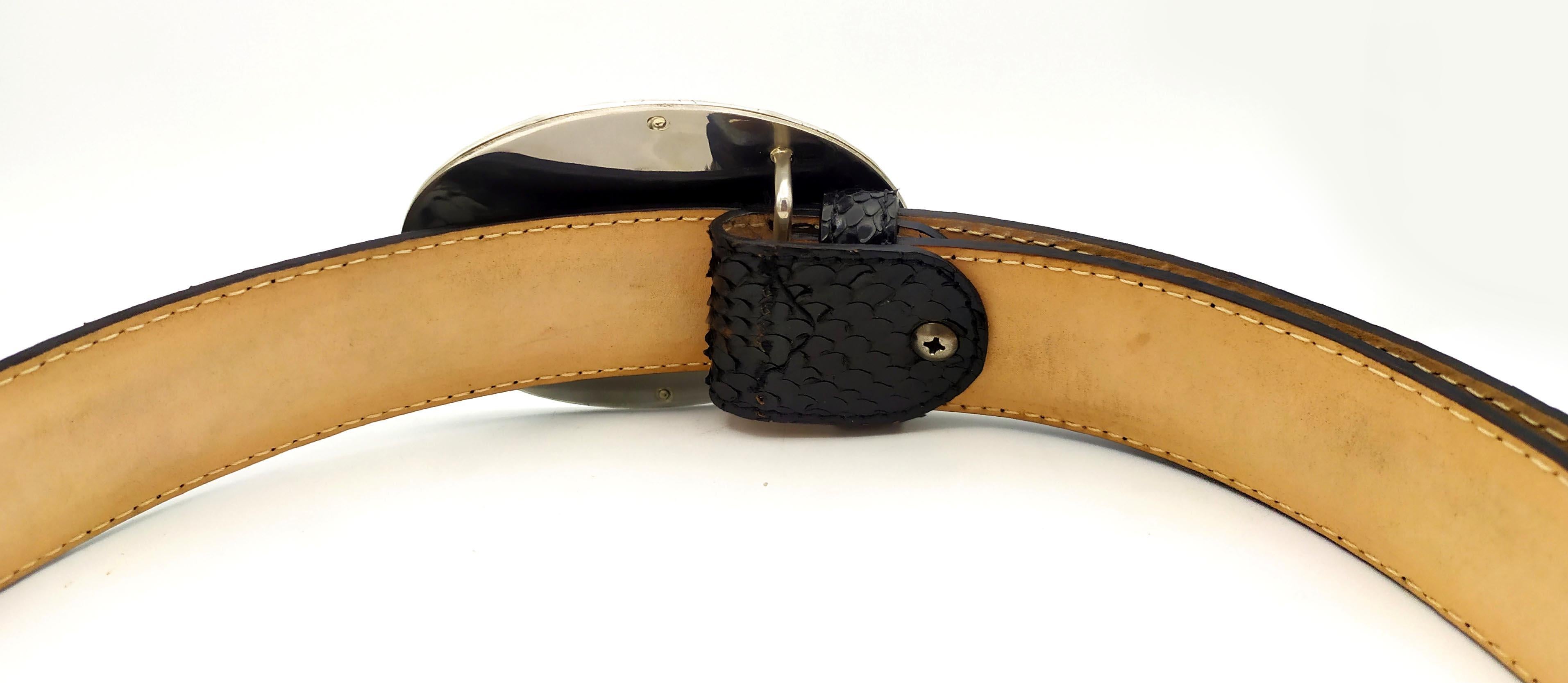 Belt in genuine black python reptile with oval buckle in 925/1000 silver with translucent fire enamel on sunburst guilloche and hand-painted miniature depicting a branch of peach blossoms, with engraved frame in modern contemporary style. Buckle