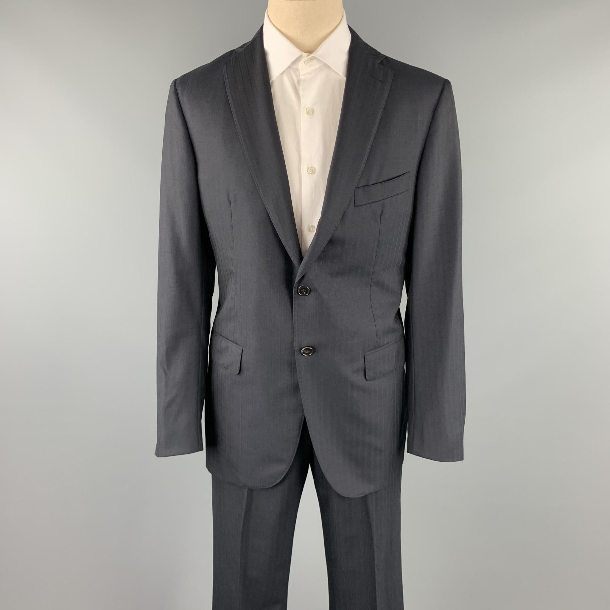 BELVEST suit comes in a black stripe wool with a full monogram print liner and includes a single breasted, two button sport coat with lapel and matching flat front trousers. Pin hole on sleeve back. As-Is. Made in Italy. 

Good Pre-Owned