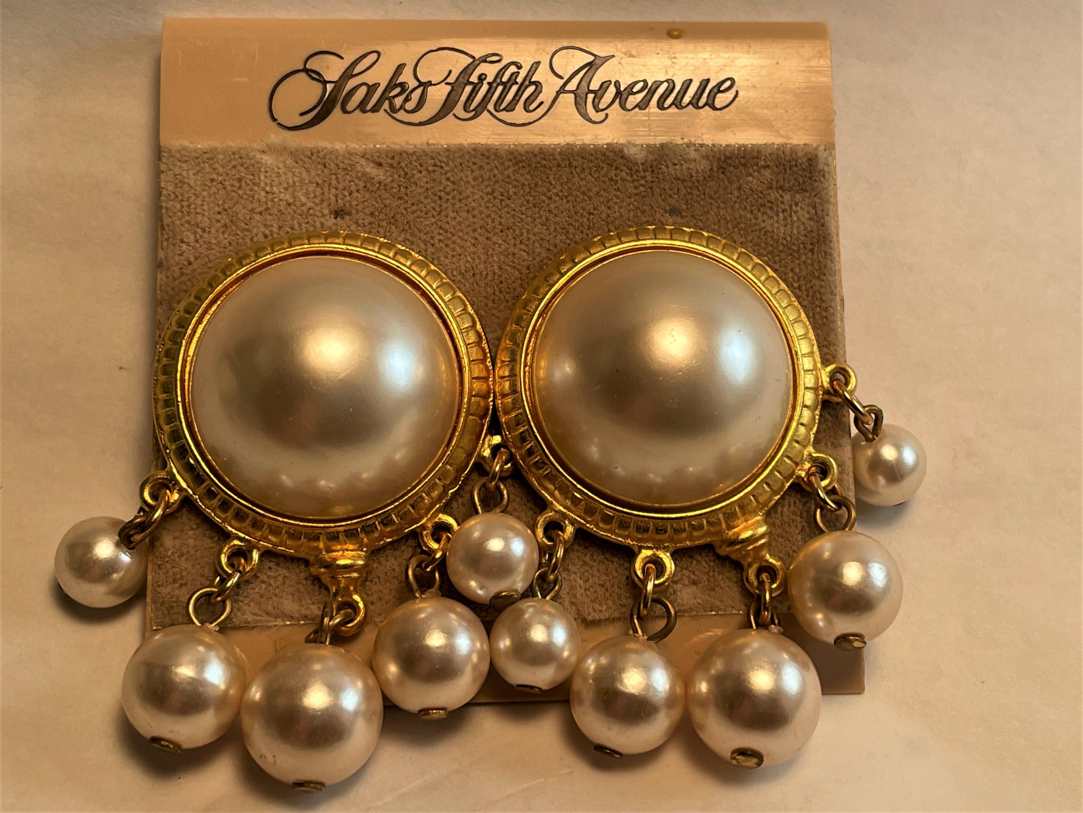 This is a fantastic pair of Ben-Amun clip on earrings with a large (about 7/8 inch diameter) vibrant faux mabe pearl surrounded by a rich, bright gold patterned frame with five lustrous bulbous pearl drops which graduate in size from each side to