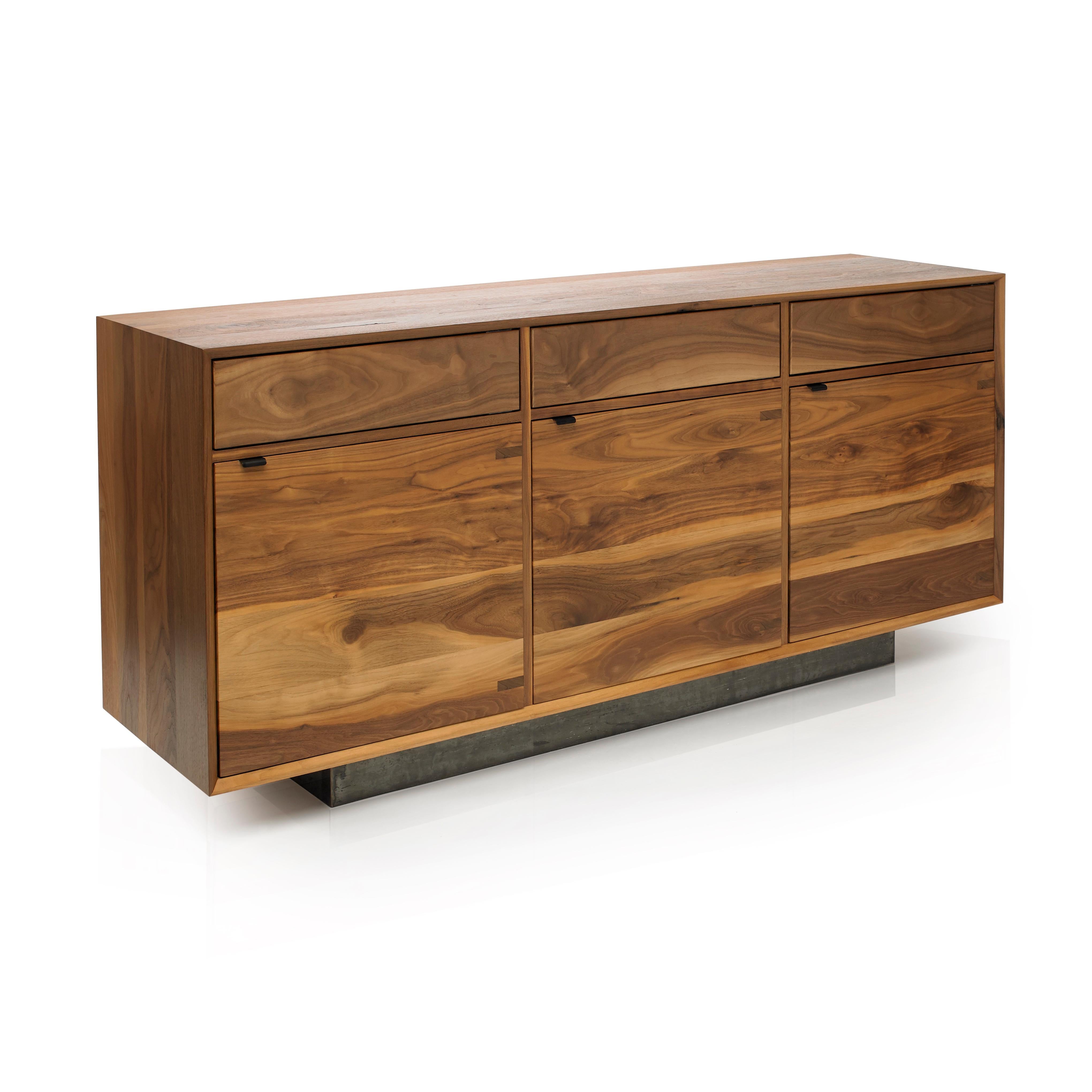 Solid black walnut credenza constructed with uncommonly practiced solid wood carcass, cabinet doors, and interior shelves. The handcrafted credenza uses push front hinged top doors for concealed storage. Black steel door pulls, soft close hinges set