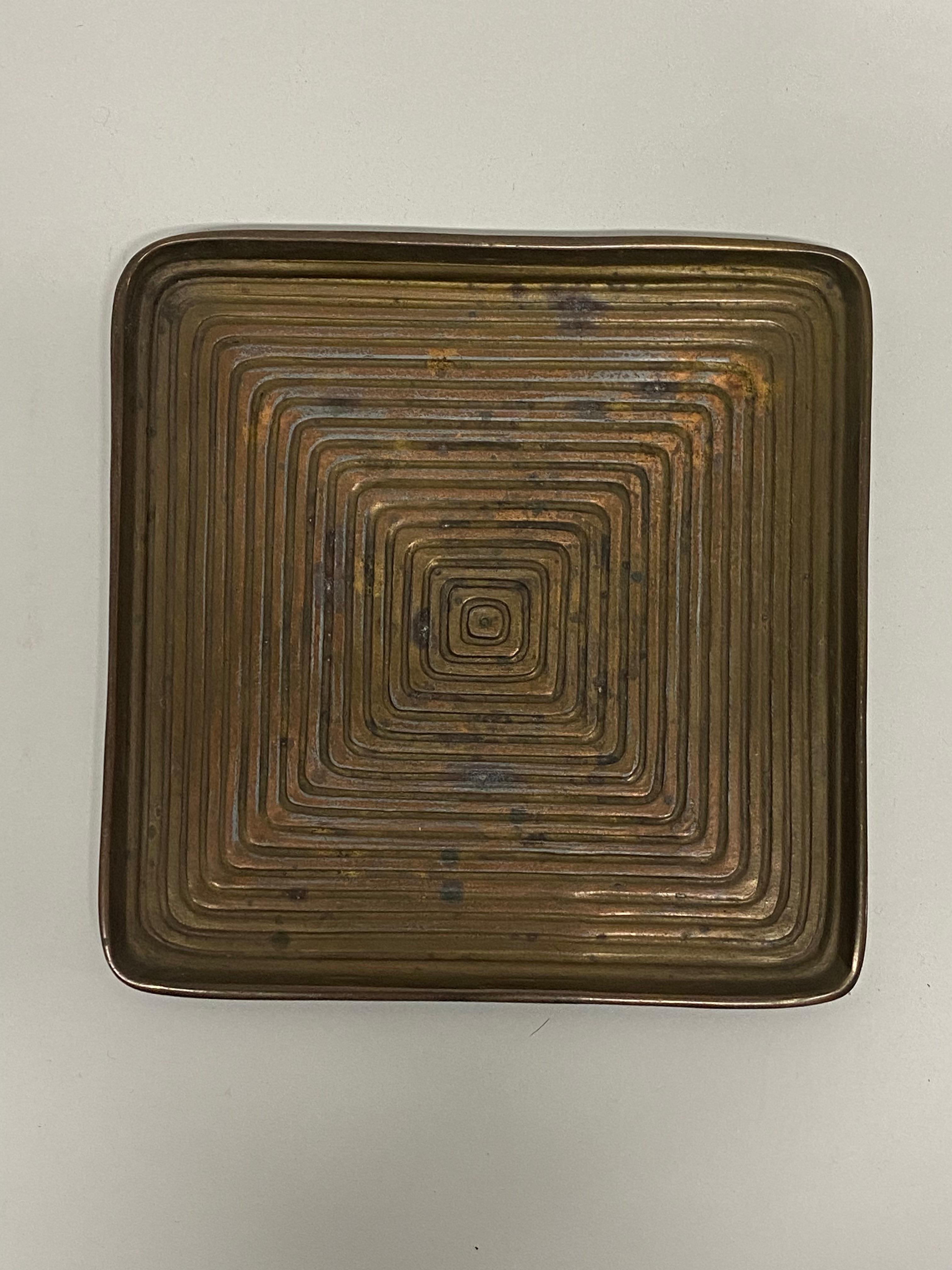Plato cuadrado concéntrico de metal fundido diseñado por Ben Seibel para Jenfred. Alrededor de 1950. Seibel crea un bonito laberinto óptico de cuadrados concéntricos cada vez más grandes. Buen estado general con pequeñas oxidaciones y pátina verdi