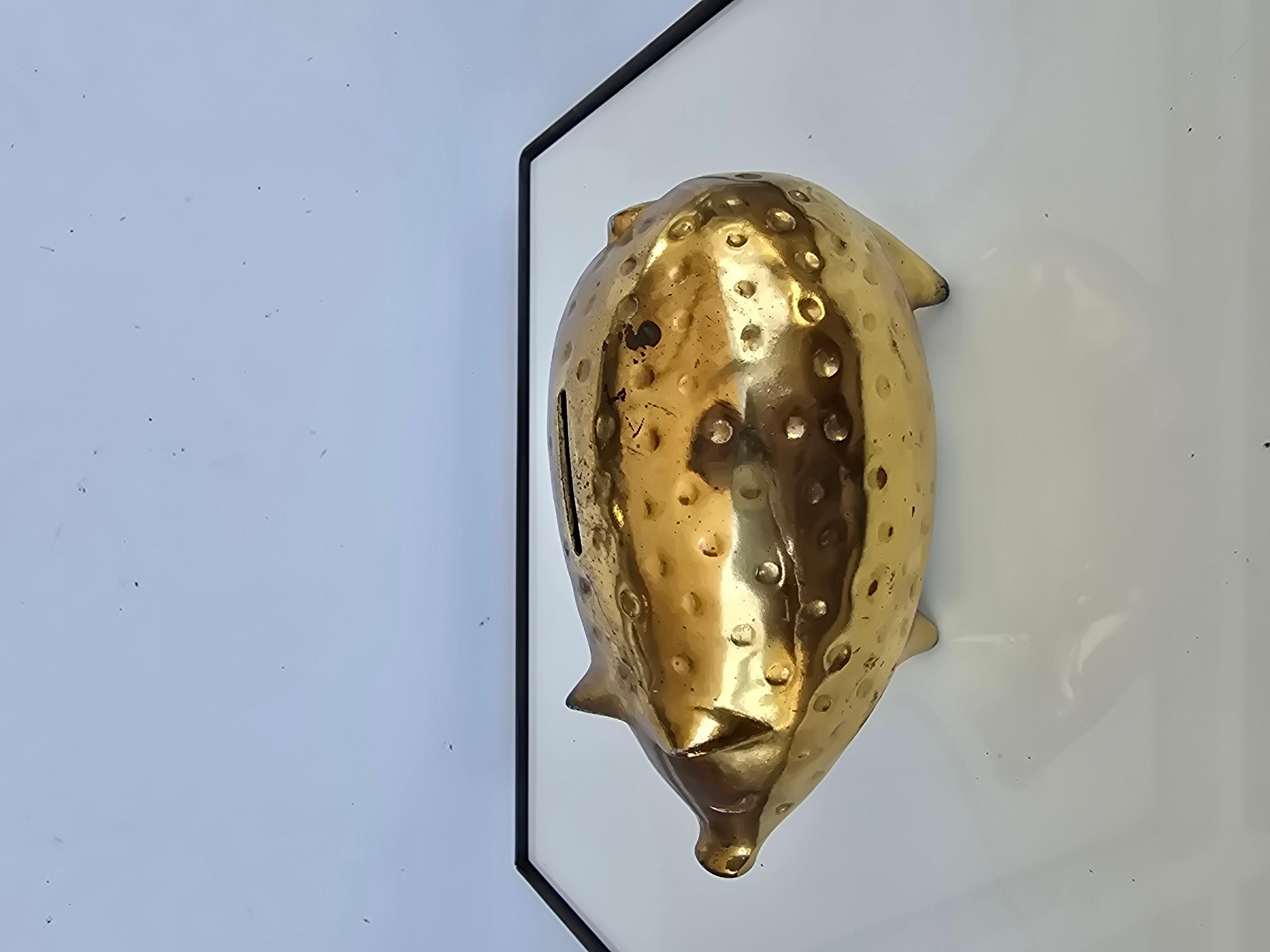 Una original hucha moderna de mediados de siglo, con forma de cerdo, diseñada por el renombrado artista Ben Seibel para Jenfredware. Esta icónica pieza está fabricada en metal de color latón, mostrando la característica mezcla de funcionalidad y