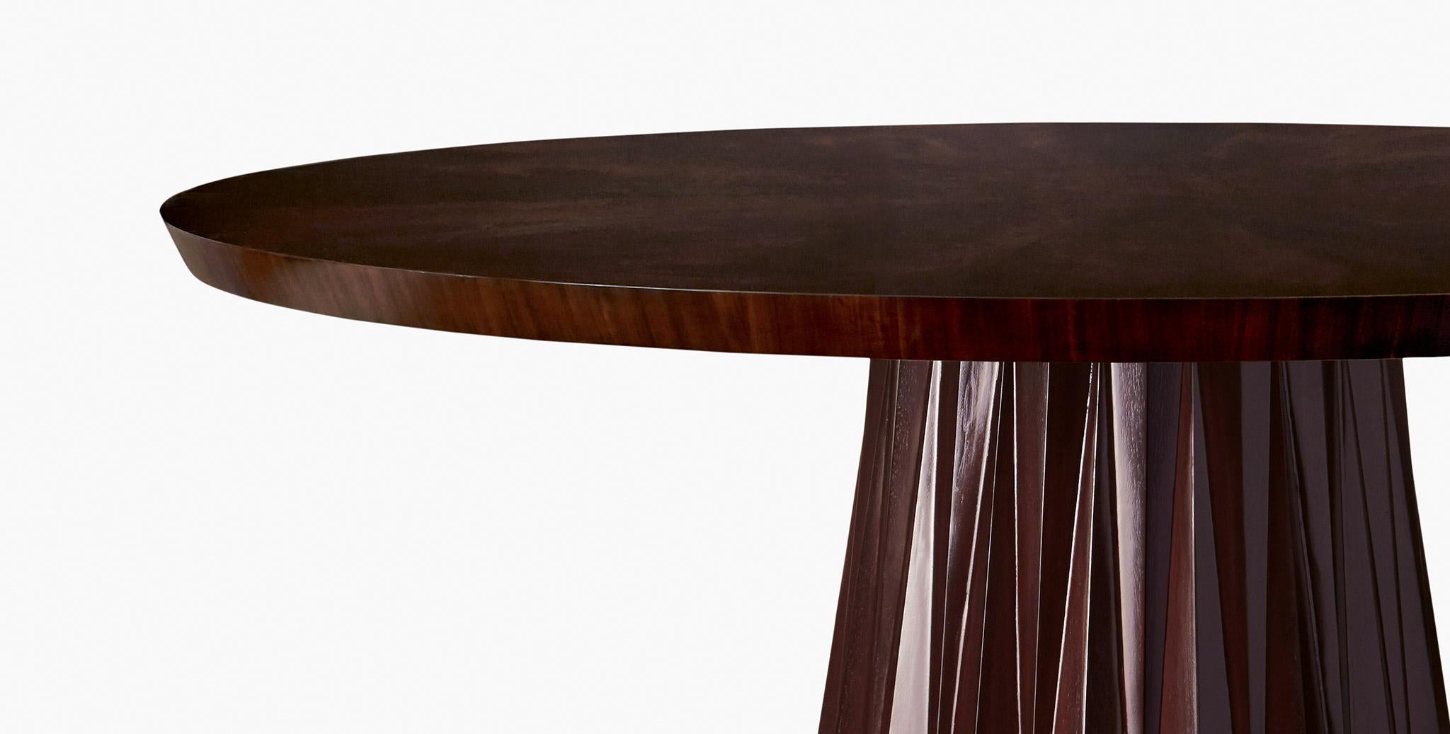 The curves of our Kingsley pedestal dining table invite conversation while the abstract fluted base provides interesting detail, enhancing the sophistication of the overall design. Walnut flame finish.
   
