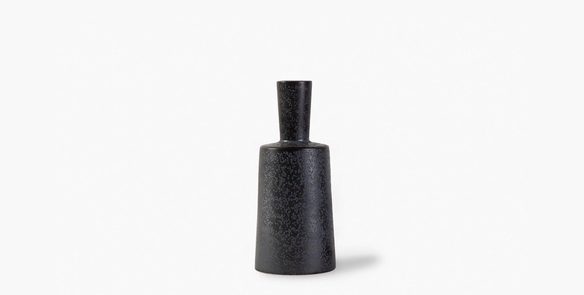 Our richly textured, metal glazed porcelain Nero vases have a modern sculptural silhouette. A narrow neck is paired with a wider base for visual contrast. Elegant on their own, or add a minimal arrangement of branches for a striking