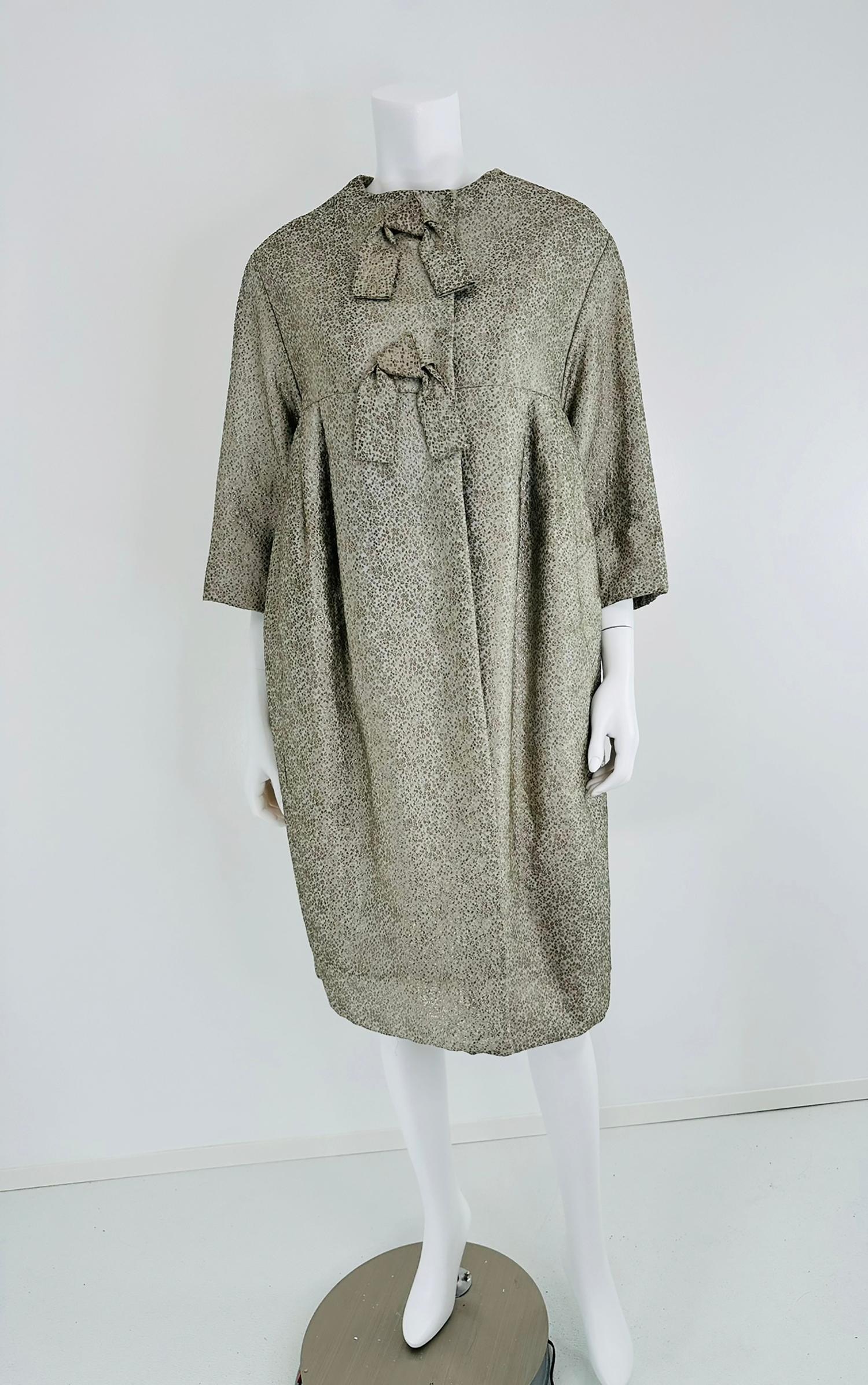 Ben Zuckerman silver & ice blue metallic brocade early 1950s sac back evening coat, coat with bow front. High round neckline, you can see in the photos the coat bodice front is cut in an empire shape, the shoulder seams are cut over the shoulder and