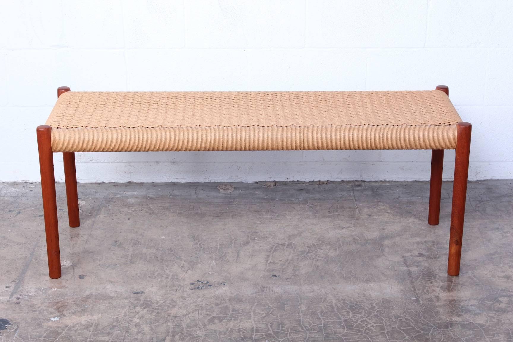 A teak bench with paper cord woven seat. Designed by Niels O. Møller, manufactured by J.L. Møllers Møbelfabrik.