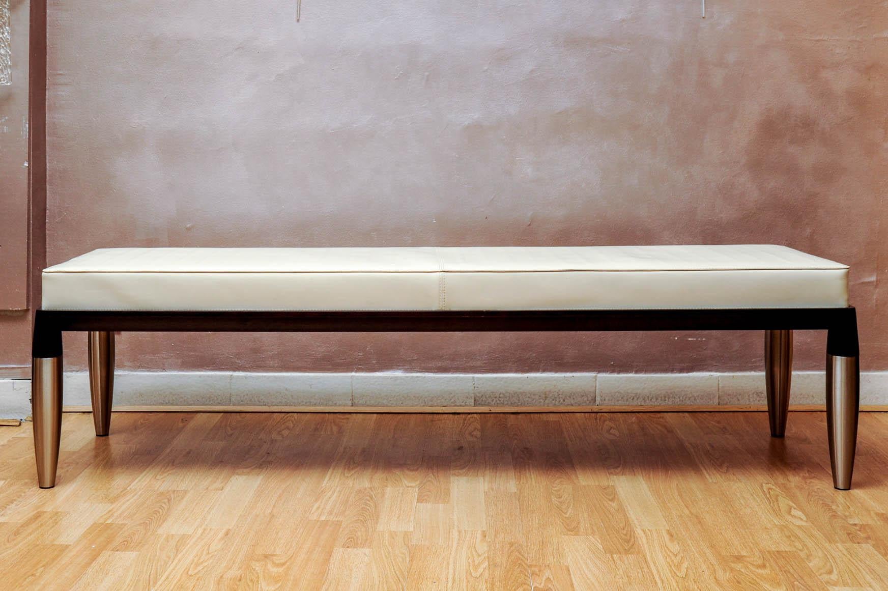 Bench covered with white leather, feet in wood and metal, signed “Giorgetti”.