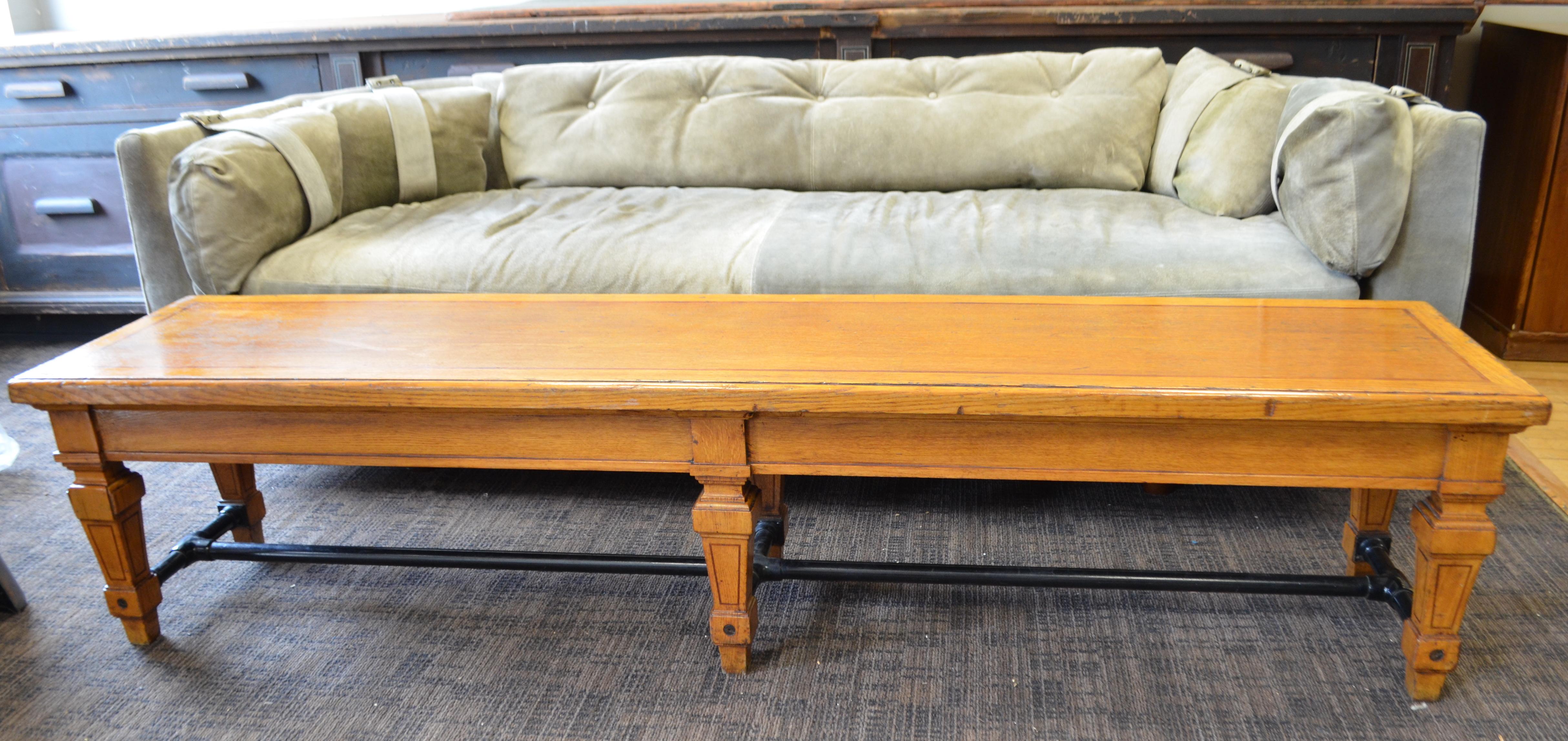 Bench from a Parisian bank, circa 1900, of hand carved oak legs and top with black steel bar supports. Strong, sturdy and secure as the bank it came from. The 78 inch width is impressive and would accommodate a long hallway or an expansive lobby