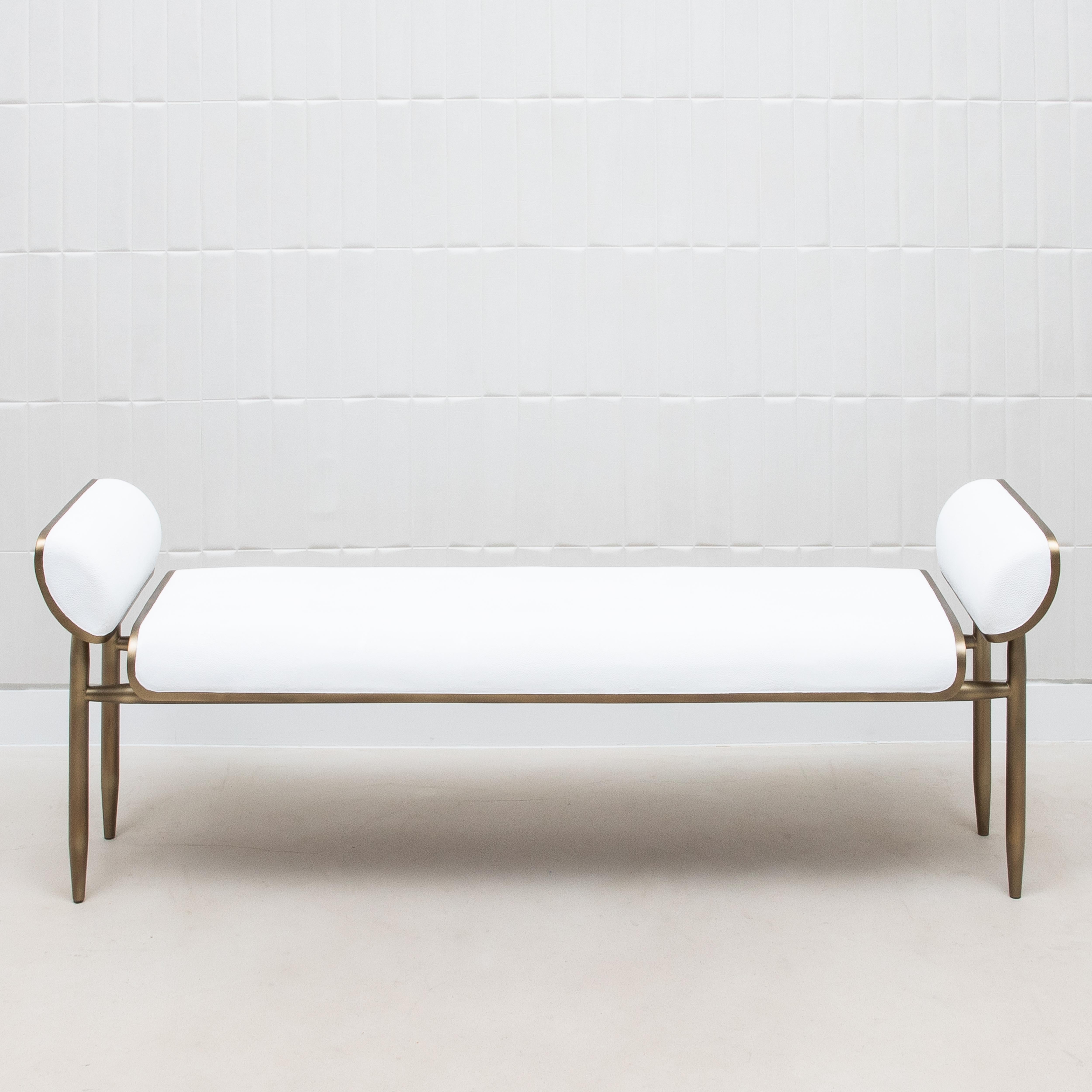 Le banc Dandy Day de Kifu Paris incarne l'élégance luxueuse avec son design épuré et sa fabrication méticuleuse. Enveloppé dans un galuchat blanc exquis, le banc est surélevé par un cadre sophistiqué en laiton patiné bronze, qui se prolonge