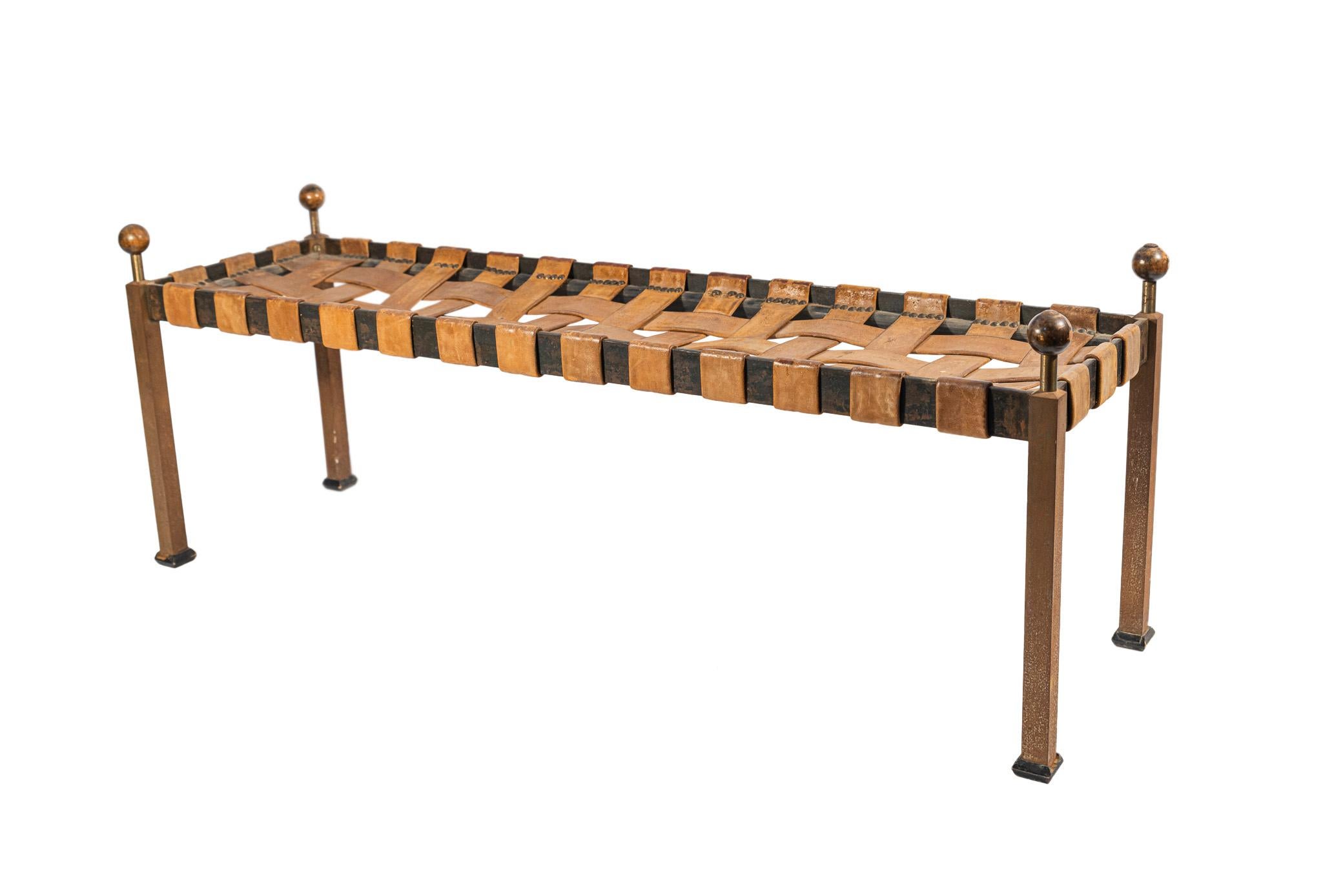 Bench in the style of the antique, 
Iron and wood,
Seating in weaved leather, 
France, circa 1940.

Measures: Width 128 cm, depth 38 cm, height 48 cm.