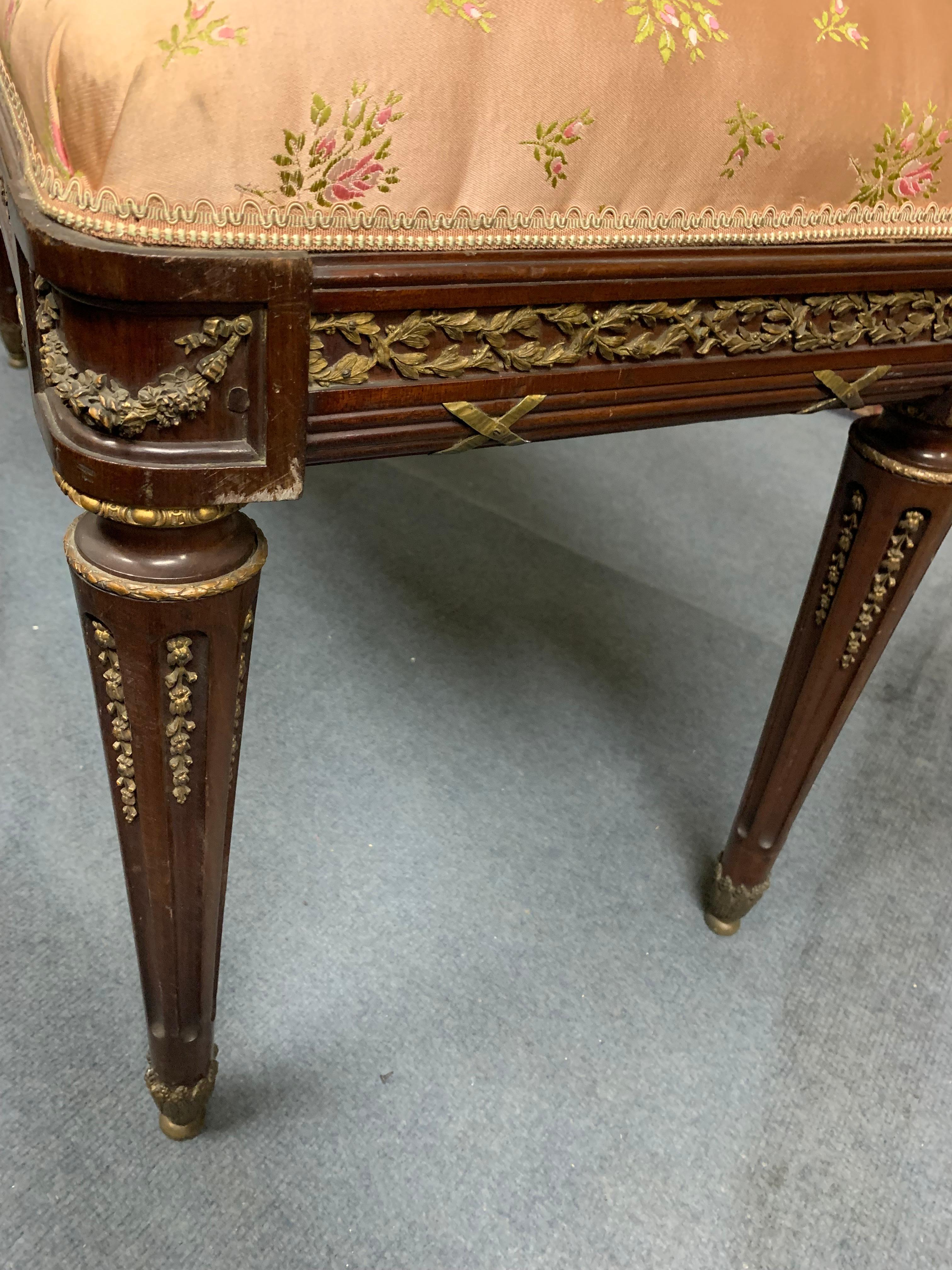 A very decorative bench louis XVI style in mohagany and bronze ,The entire belt of the bench is surronded by finely chiseled bronze, the top of the footis surronded by a bronze ring and you have bronze palmettes inside the feet which are finishedby