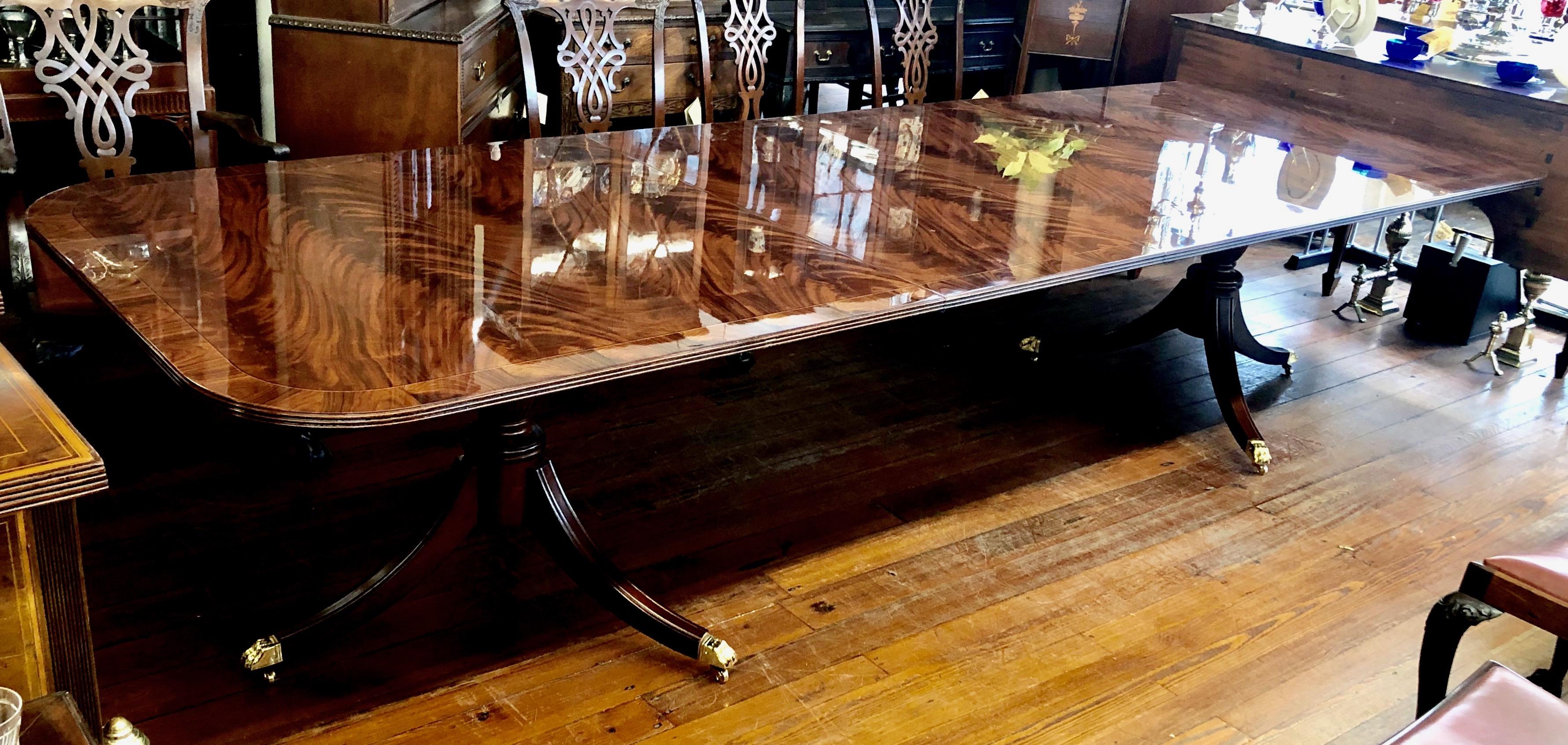 Exquisite quality domestically bench made reproduction inlaid and slip-matched flame or crotch mahogany Sheraton style two pedestal, two leaf dining table. Please note the extraordinary highly figured slip-matched (reverse laid) crotch mahogany with