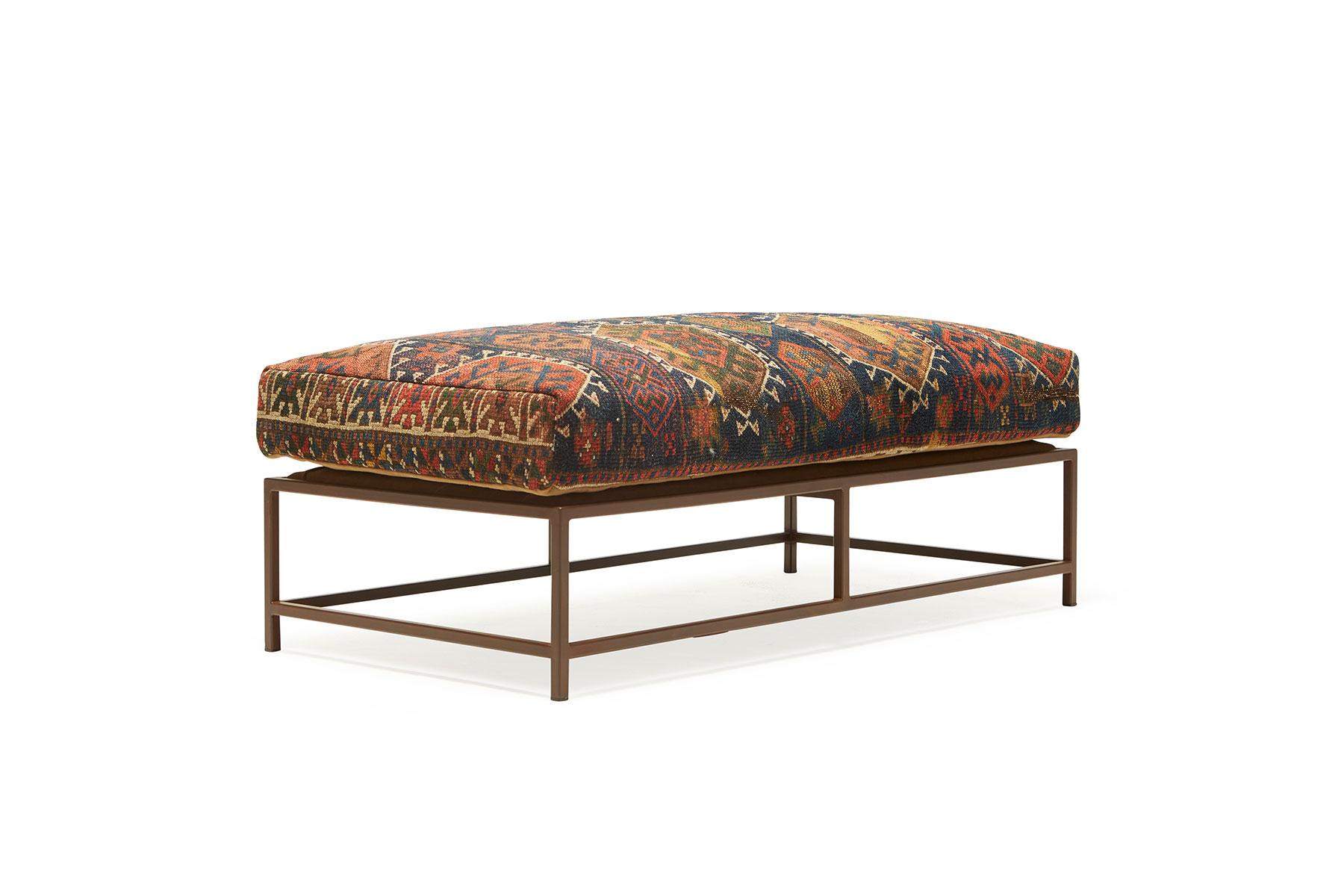 This bench, in the style of Stephen's Kenn Inheritance Collection, has been upholstered with an antique rug from the collection of King Kennedy rugs. The textile has been lovingly repaired and reinforced, without losing any of the beautiful