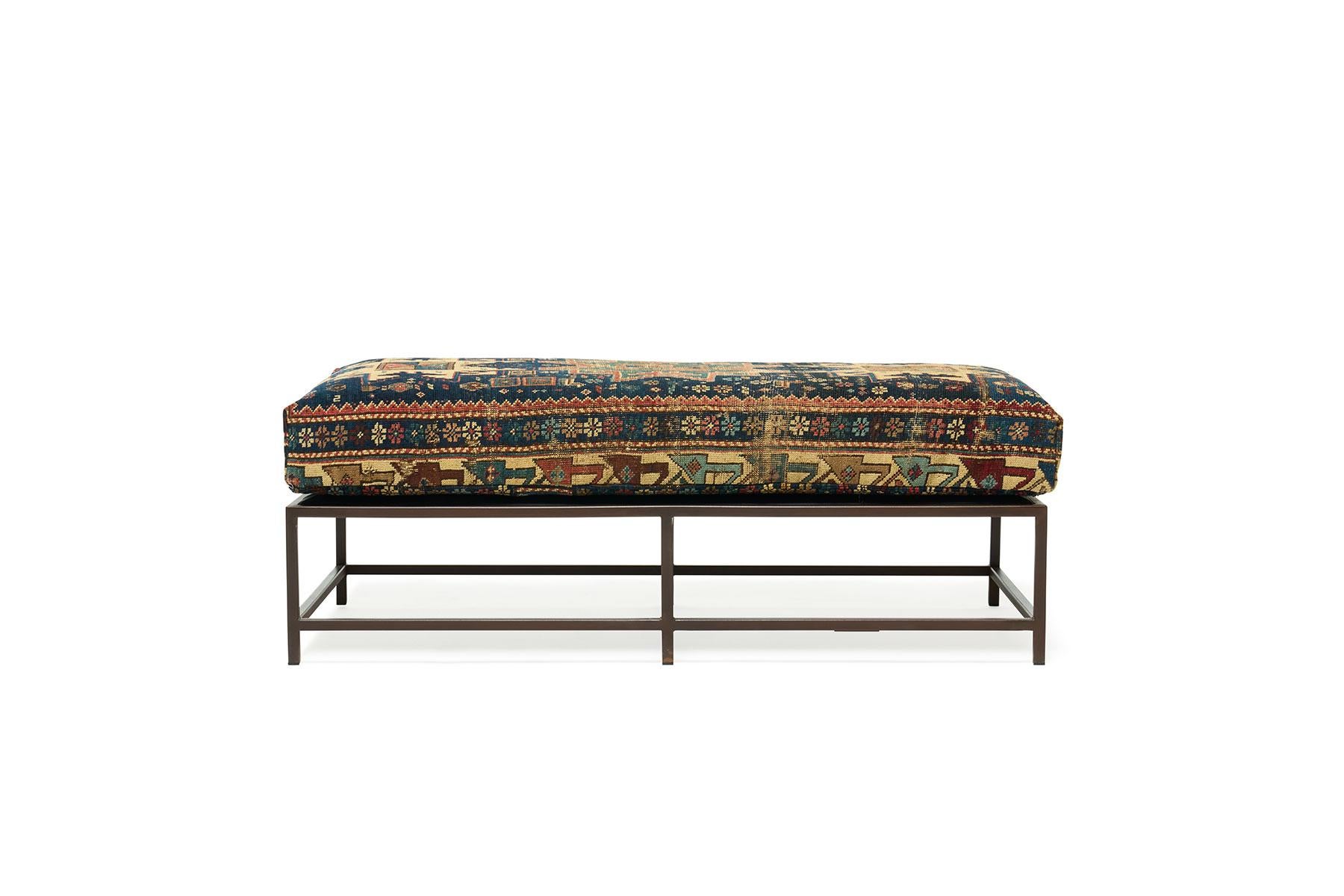 This bench, in the style of Stephen's Kenn Inheritance Collection, has been upholstered with an antique rug from the collection of King Kennedy rugs. The textile has been lovingly repaired and reinforced, without losing any of the beautiful