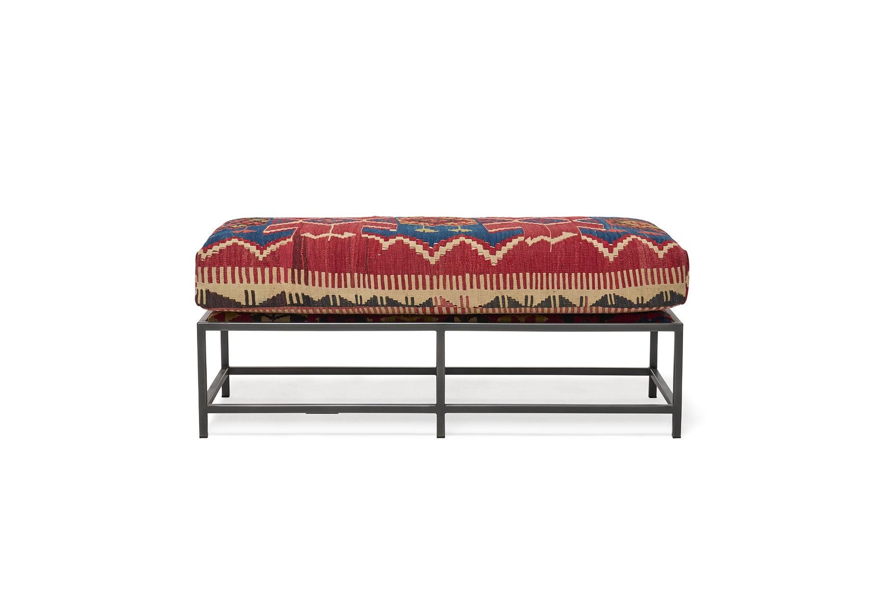 This bench, in the style of Stephen's Kenn Inheritance Collection, has been upholstered with an antique rug from the collection of King Kennedy rugs. The textile has been lovingly repaired and reinforced, without losing any of the beautiful