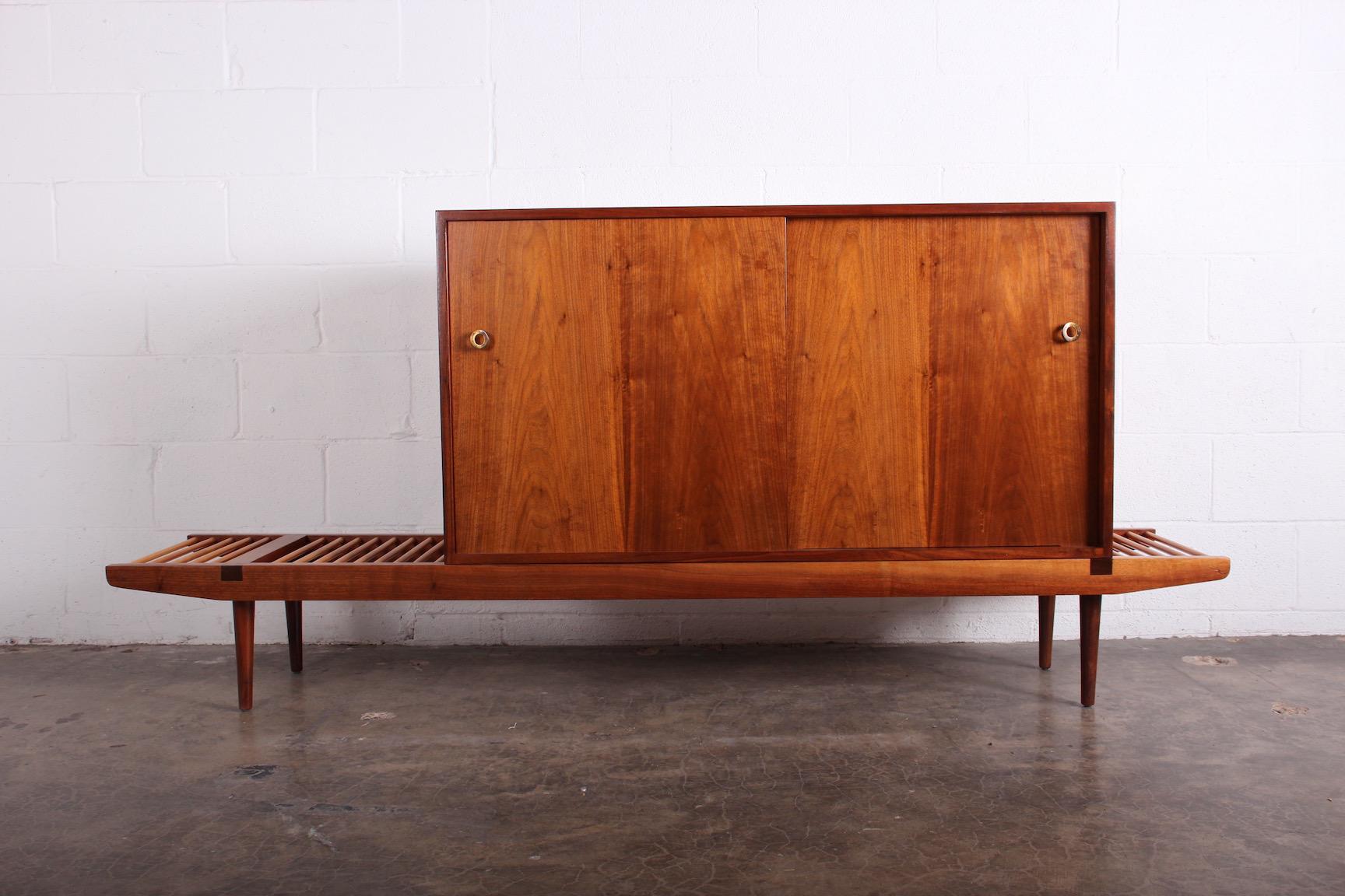 A beautifully restored walnut cabinet that sits atop a maple and walnut bench. Attributed to Milo Baughman and Greta Grossman for Glenn of California.