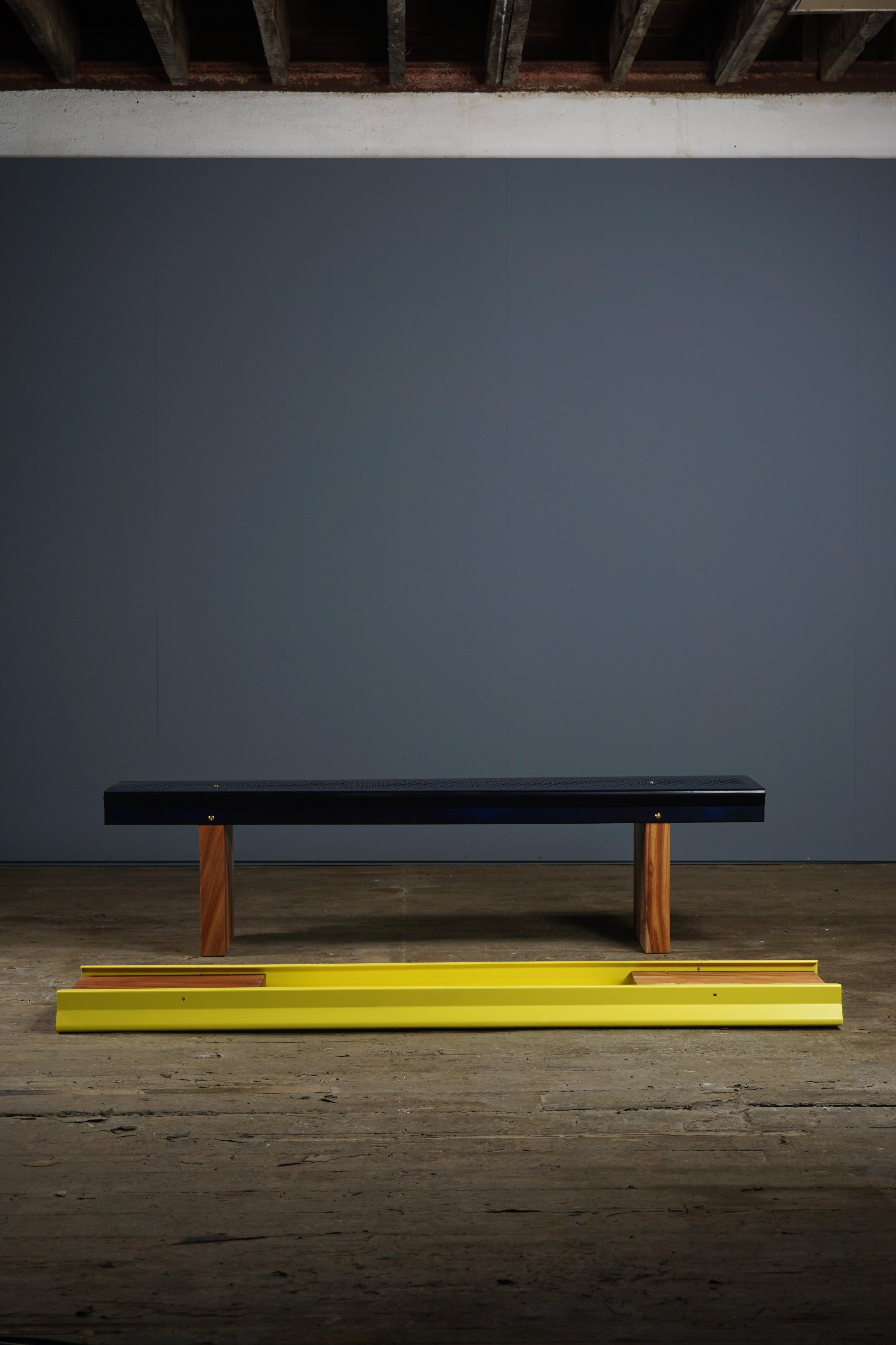 Powder coated in sulfur yellow, the aluminium part is formed in one piece. The perforated metal piece connects to two solid Mahogany legs through blackened steel bolts.
Suitable for indoors only.

Dimensions: 
36cm x 180cm x 45cm 
14