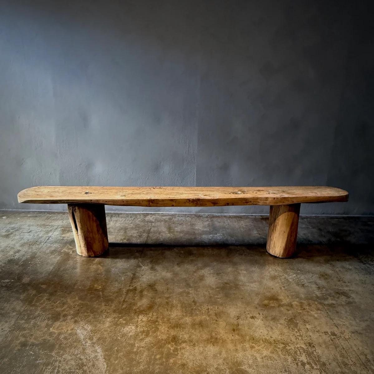 Queste due panche rustiche mostrano la bellezza senza tempo del legno naturale. Le loro forme robuste e semplici enfatizzano la consistenza organica e la ricca patina sviluppata in decenni di utilizzo. Ogni panchina poggia su gambe robuste e spesse