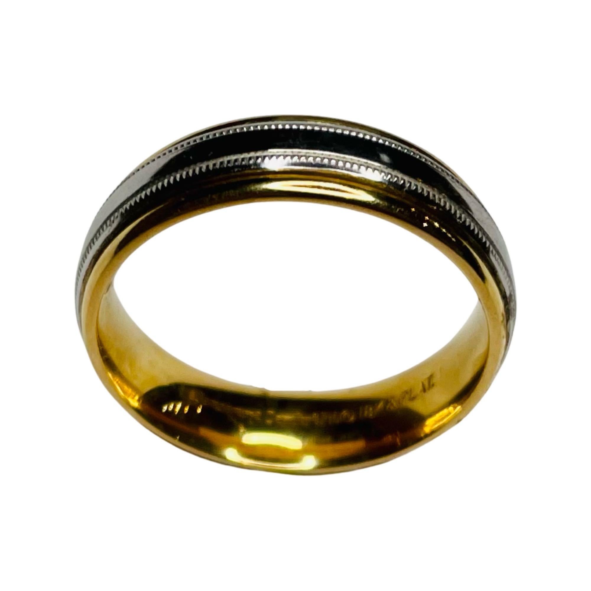 Benchmark Platinum and 18K Yellow Gold Wedding Band. This ring is 6.0 mm wide.  It is comfort fit. It is finger size 10.0, but we can size this for an additional fee. It has two decorative milgrained strips.
100-100-136