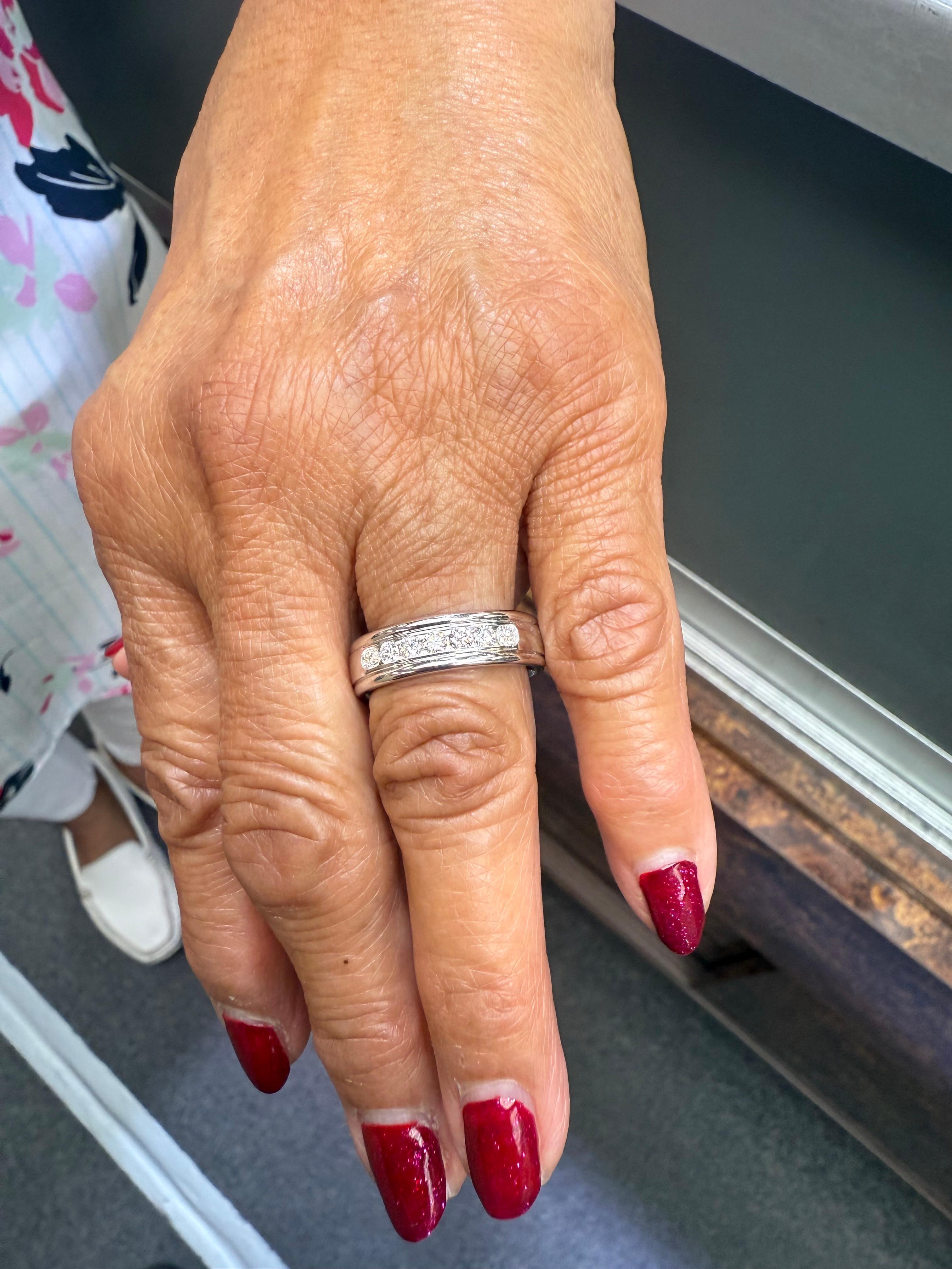 Alianza de oro blanco de 14k con siete diamantes.

La Alianza de Boda Benchmark Siete Diamantes de Oro Blanco de 14k está engastada en canal con diamantes redondos de talla brillante.  Benchmark la llama la banda estilo Roosevelt.  Es una cinta de