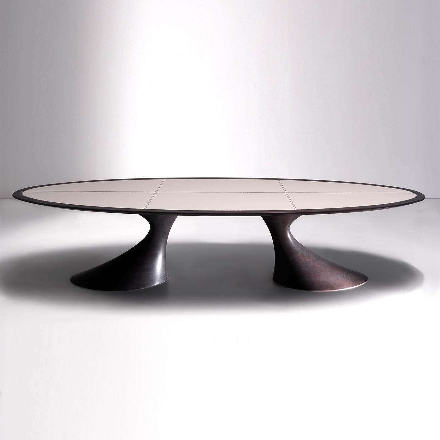 Cette table à manger sculpturale est un meuble splendide autour duquel se réunir. Son profil intriguant est marqué par des courbes douces et dramatiques dans un design qui prendra la vedette dans tout décor contemporain. Le design sinueux et