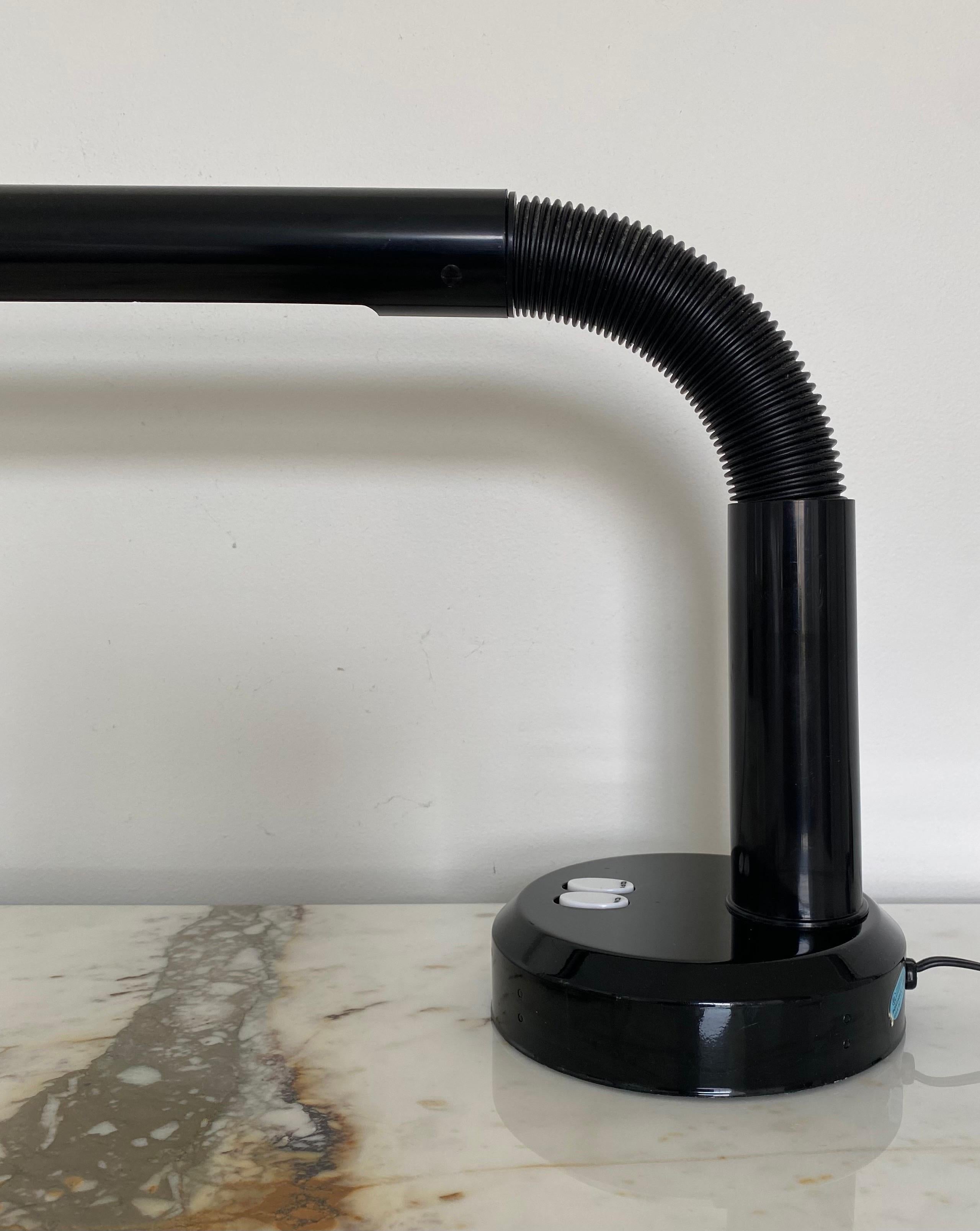 Post Modern tubular task desk lamp in the style of Swedish designer Anders Pehrson.  This highly functional linear table lamp features a sleek tubular shade that is bendable to direct the light beam as desired.  This black high gloss lamp is in