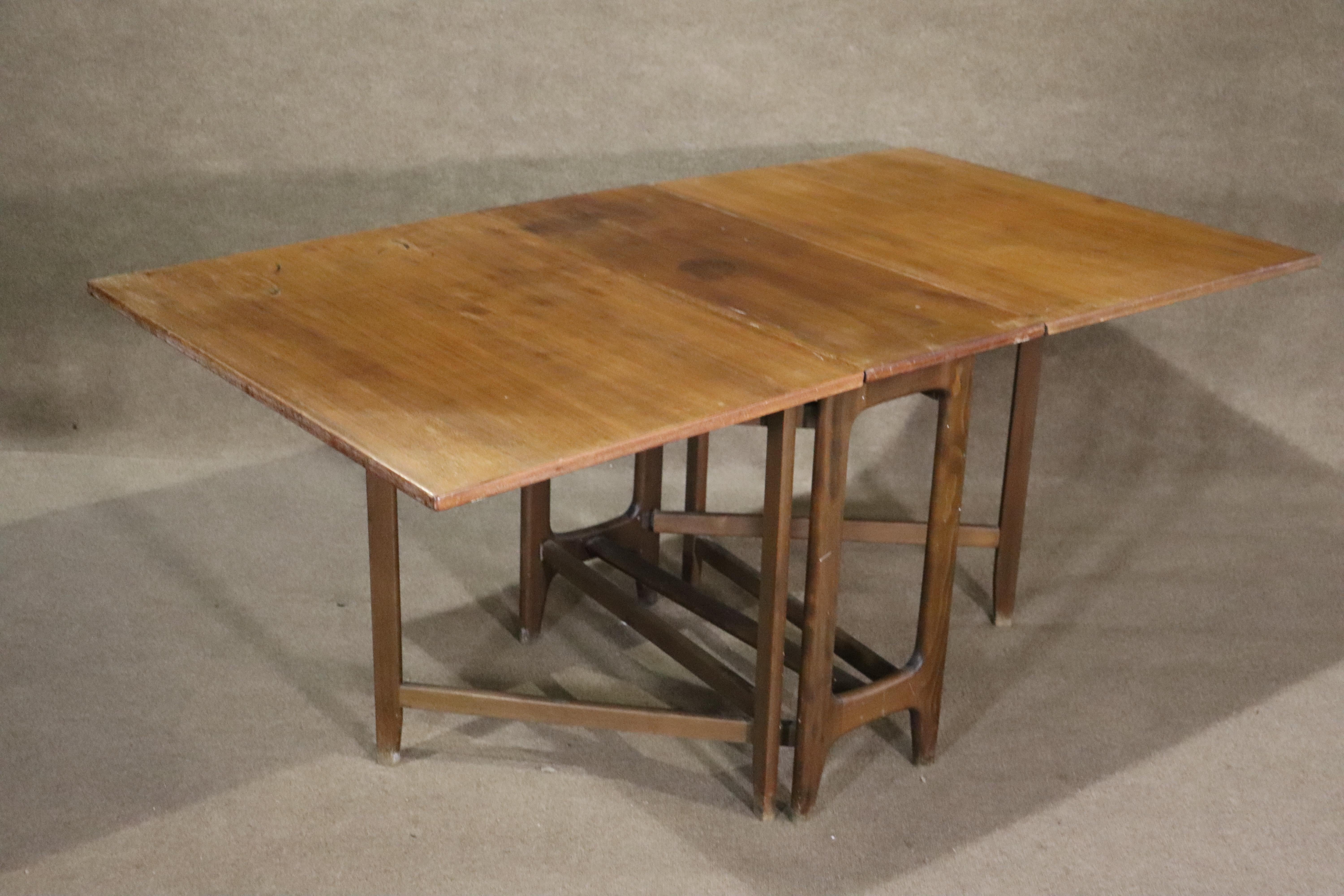 This mid-century modern teak dining table is perfect for your small apartment or extra hosting space. With two leaves that fold, it can go from 14