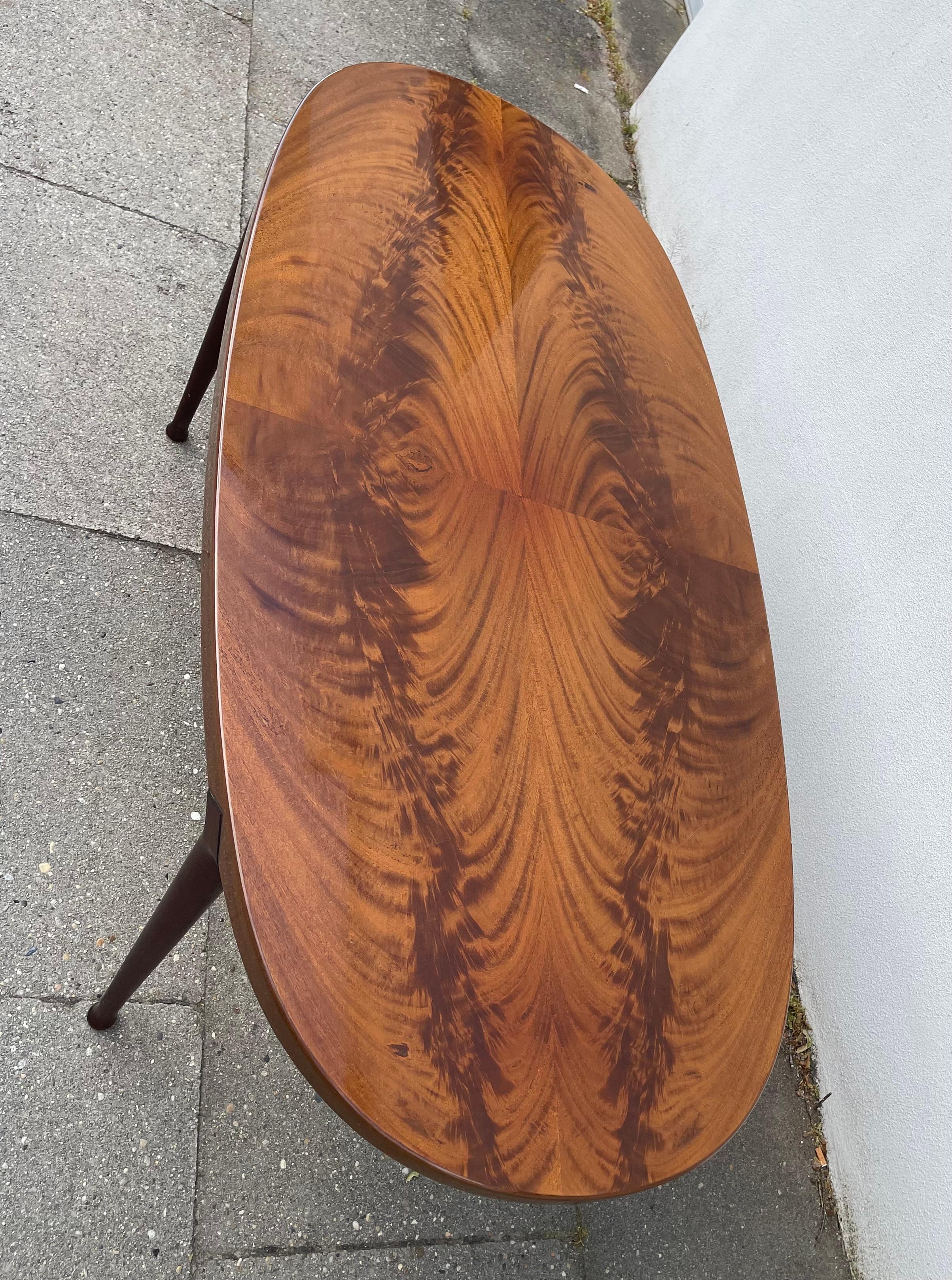A rare high-quality oval/elliptical coffee table number 514 designed by Bendt Winge and made  at Aase Dreieri in Norway during the 1950s. The table features Mirrored Persian Walnut table top and Mahogany drum-stick legs with architectural details up