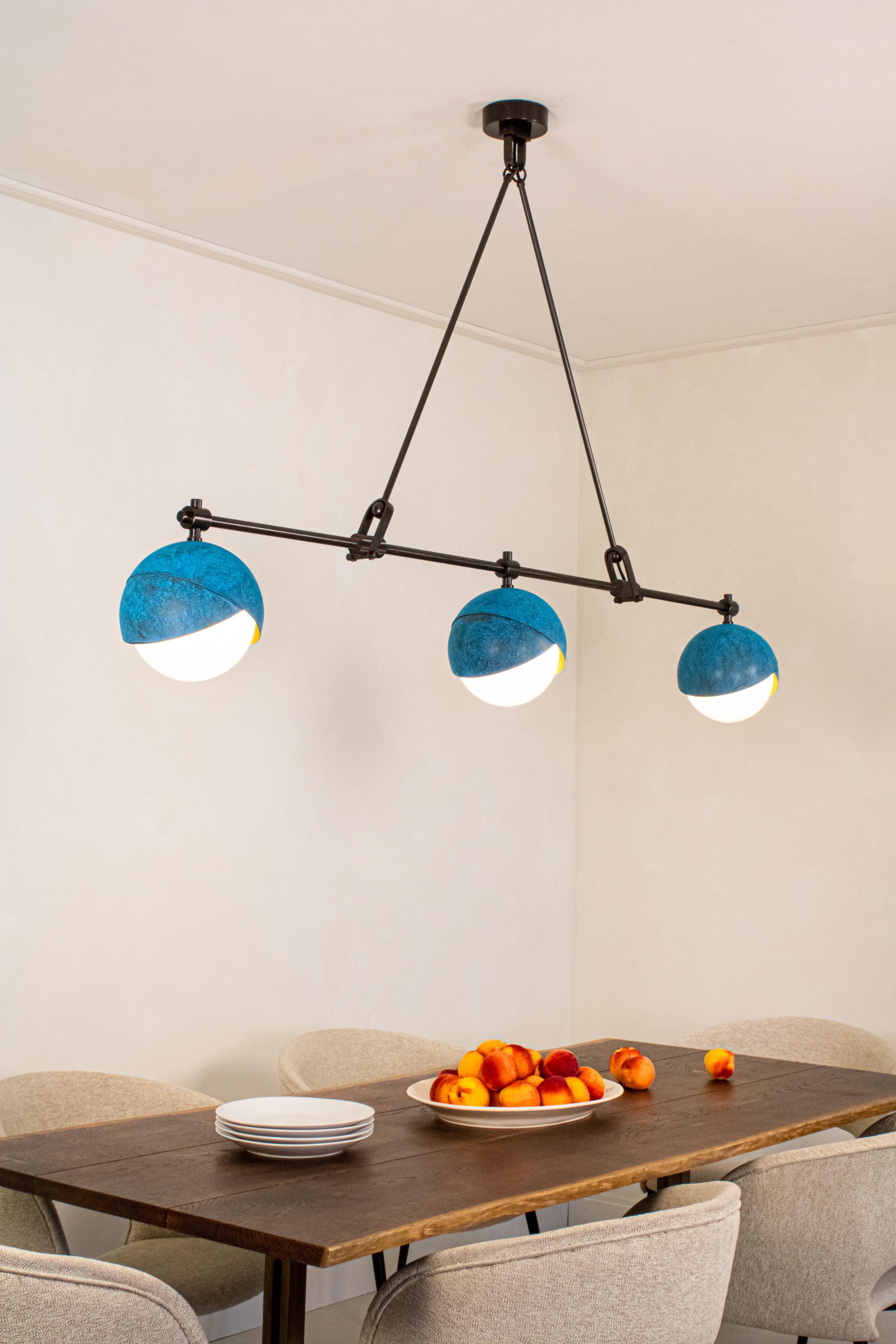 Trois ensembles de lumières Benedict™ de 9 pouces forment un réseau linéaire maintenu par une menuiserie finement détaillée. Disponible dans toutes les hauteurs, ce lustre est une pièce maîtresse invitante pour tout îlot de cuisine, table à manger,