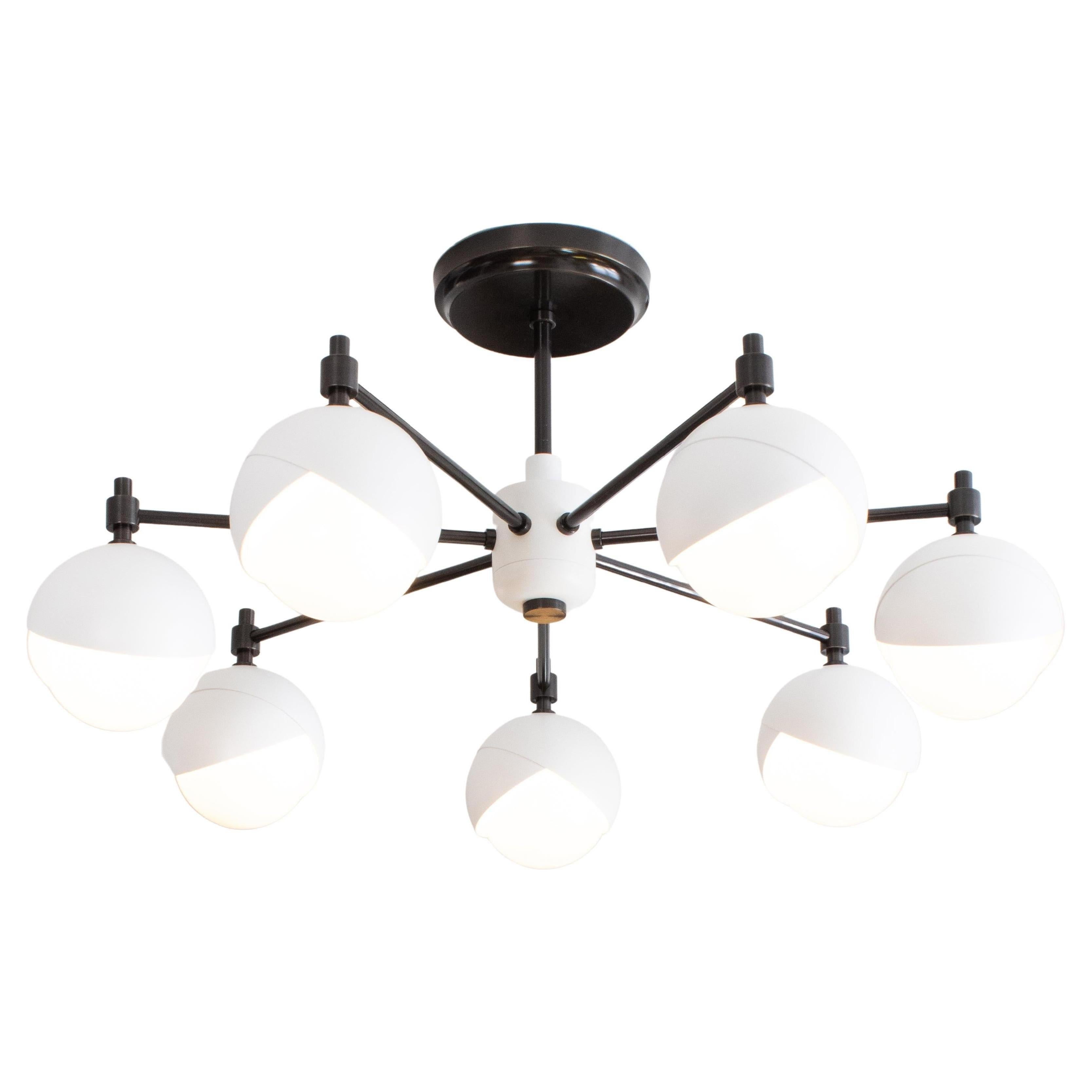 The Benedict™ seven light chandelier showcases a circular array of 6 inch Benedict™ light assemblies in grand fashion. Available in a variety of powder coat colors and metal finishes. Shown here in Matte White powder coat and Blackened brass.