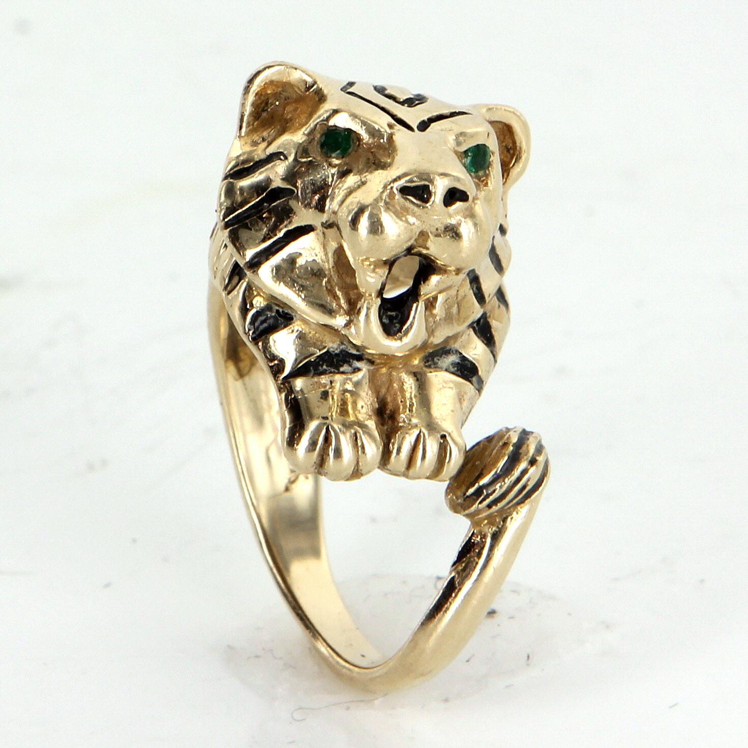 Fein gearbeiteter Ring mit bengalischem Tiger aus 14 Karat Gelbgold. 

In die Augen sind Smaragde mit einem geschätzten Gesamtwert von 0,06 Karat eingelassen.

Der Ring wiegt 19 Gramm und hat ein schönes, schweres Gewicht, das an der Hand gut zur