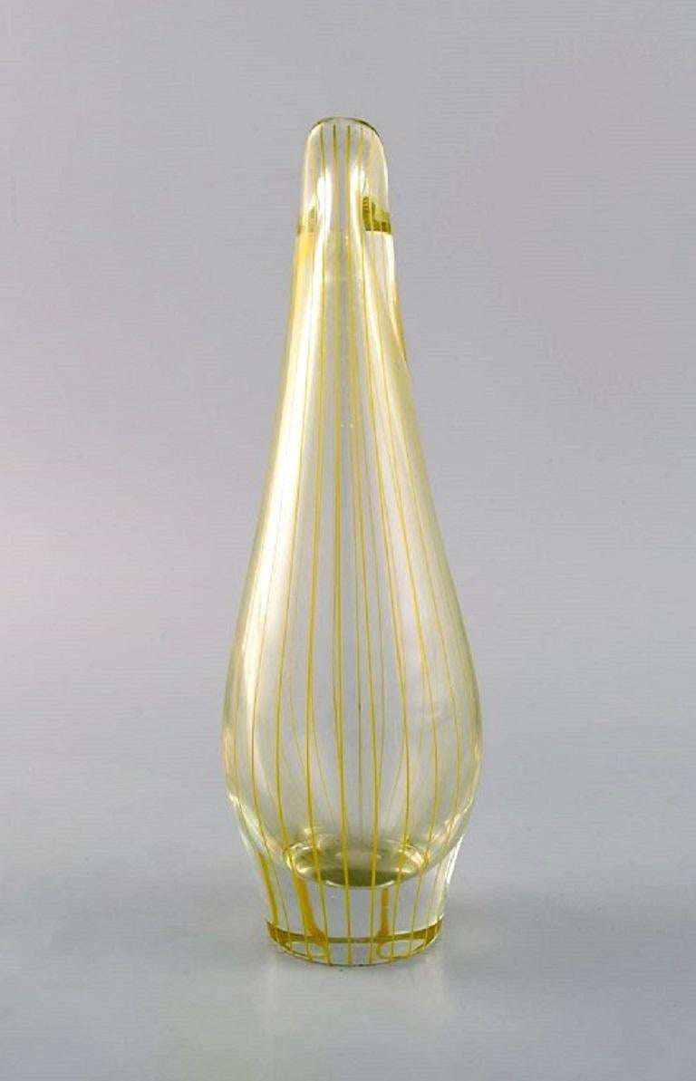 Bengt Orup (1916-1996) pour Johansfors. Vase strict en verre d'art soufflé à la bouche transparent à rayures verticales jaunes. 1960s.
Mesures : 20.5 x 6,5 cm.
En parfait état.
