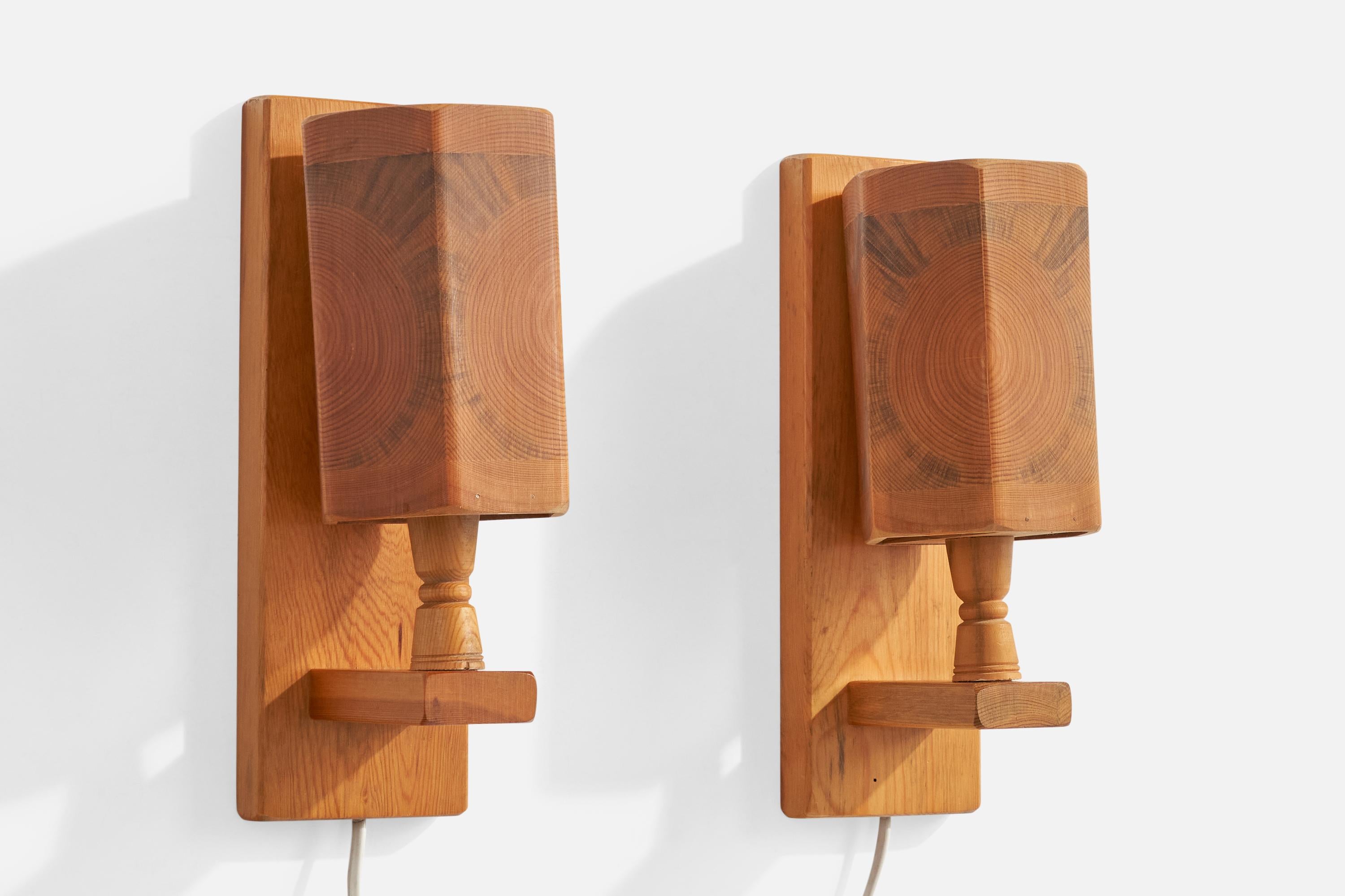 A pair of pine wall lights designed and produced in Sweden, c. 1970s.

Overall Dimensions (Inches): 11.25” H x 3.8” W x 4.8” D

Back Plate Dimensions (Inches): 11.25” H x 3.8“ W x .75” D

Bulb Specifications: E-14

Number of Sockets (per fixture):