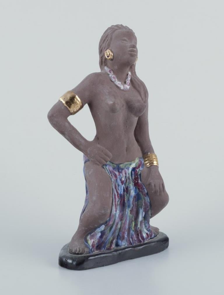 Bengt Wall, Suecia. 
Figurilla de una niña de Bali en cerámica cruda y esmaltada con decoración dorada.
1950s. 
En excelente estado.
Firmado.
Medidas: A 22,0 cm. x A 11,5 cm.