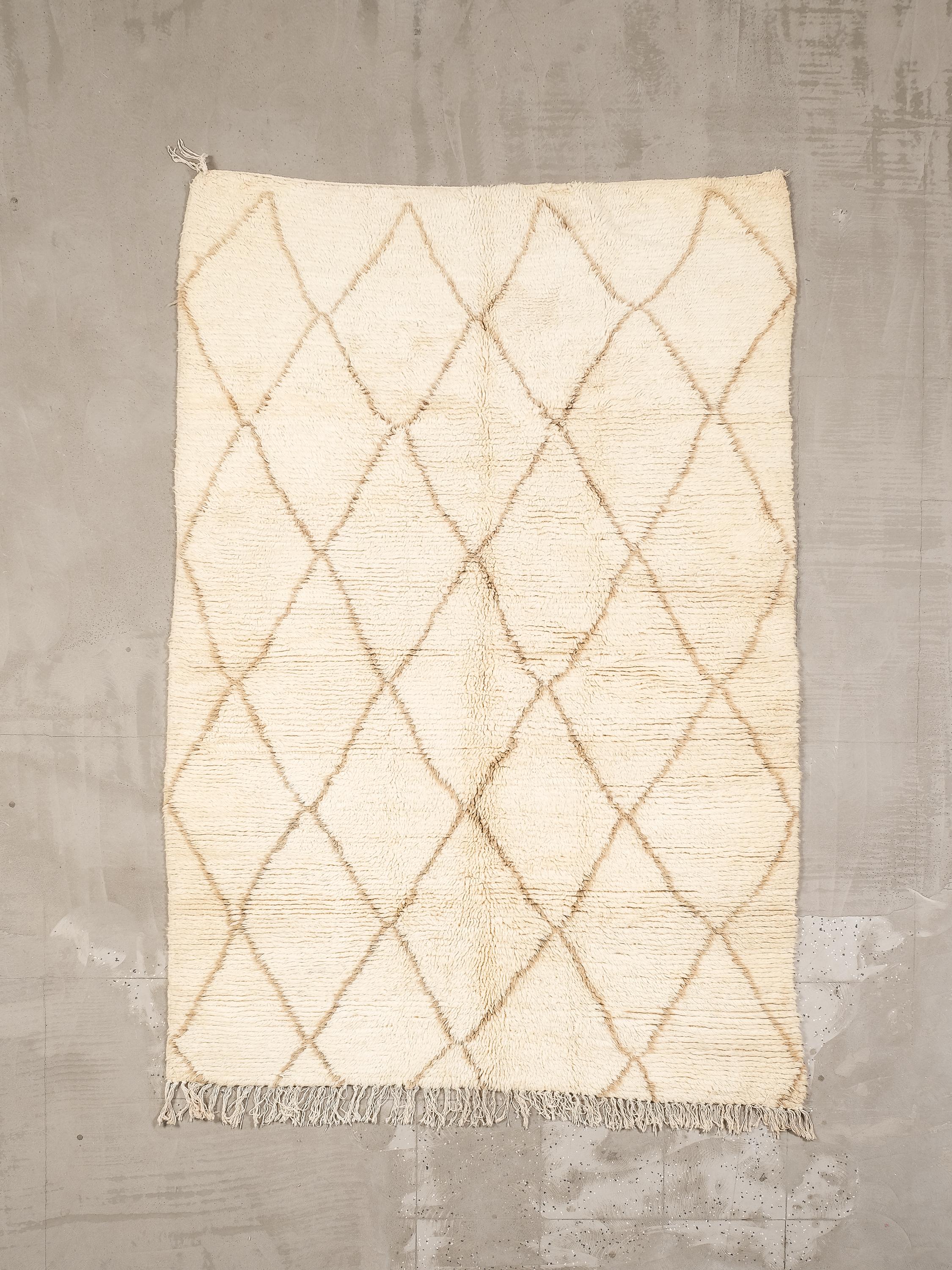 Ein wunderschöner handgefertigter Beni Ouarain-Teppich, gewebt von Berber-Kunsthandwerkern im Mittleren Atlasgebirge in Marokko. Dieses Stück hat einen zarten cremeweißen Sockel, der elegant mit einem klassischen Rautengittermotiv in beigen