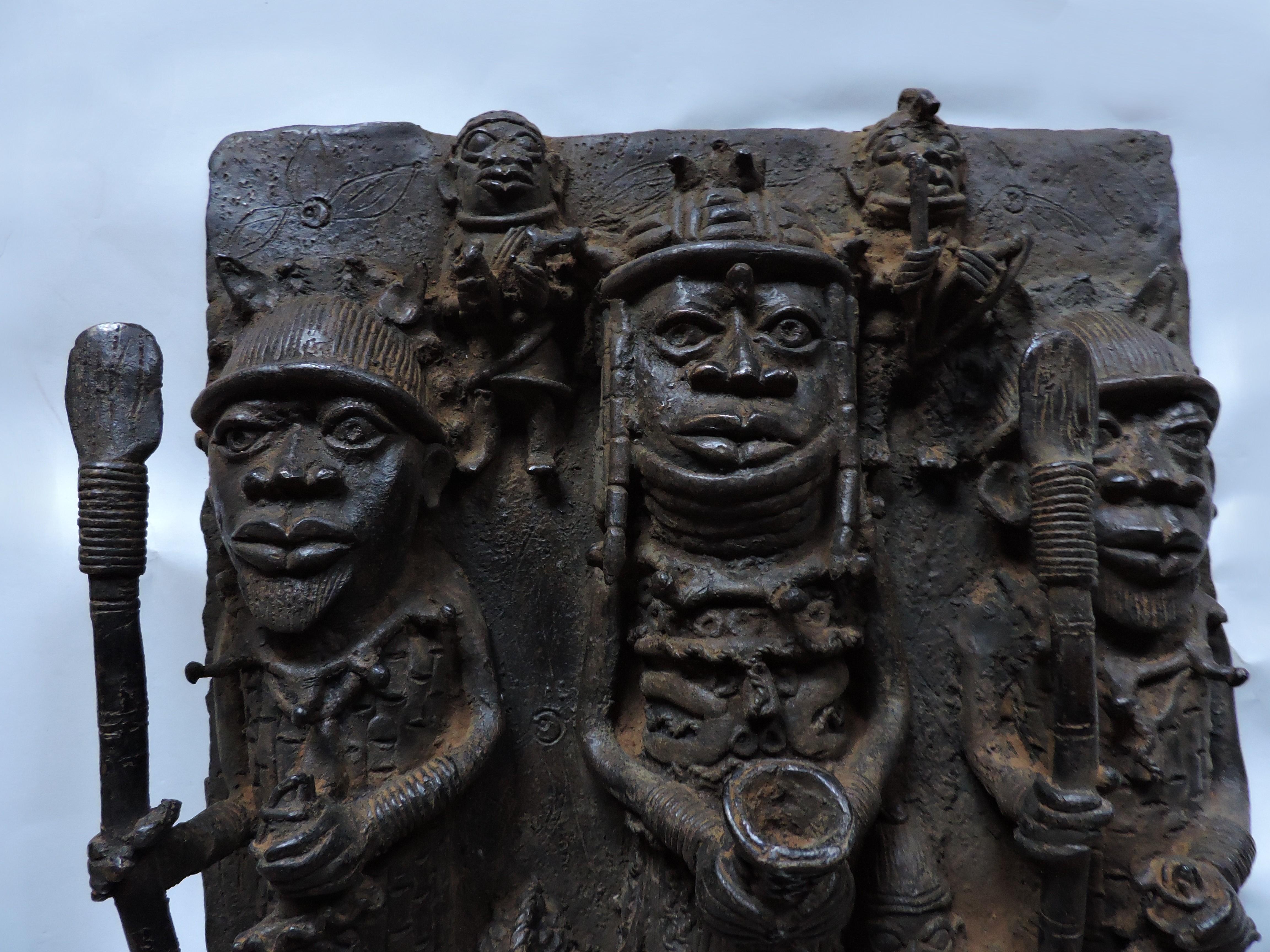 Sculpture en bronze en relief, étonnante et détaillée, provenant du Bénin, aujourd'hui connu sous le nom de Nigeria, en Afrique. Cette pièce a été modelée d'après d'anciens bronzes du Bénin, mais elle date du 20e siècle. L'imagerie complexe a été